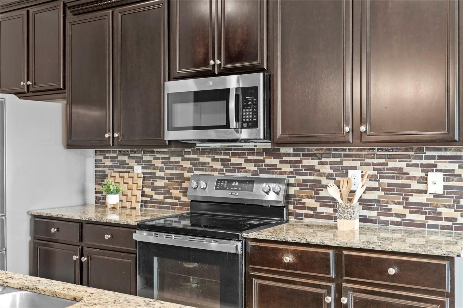 Granite counters, glass tile backsplash and upgraded stainless appliances