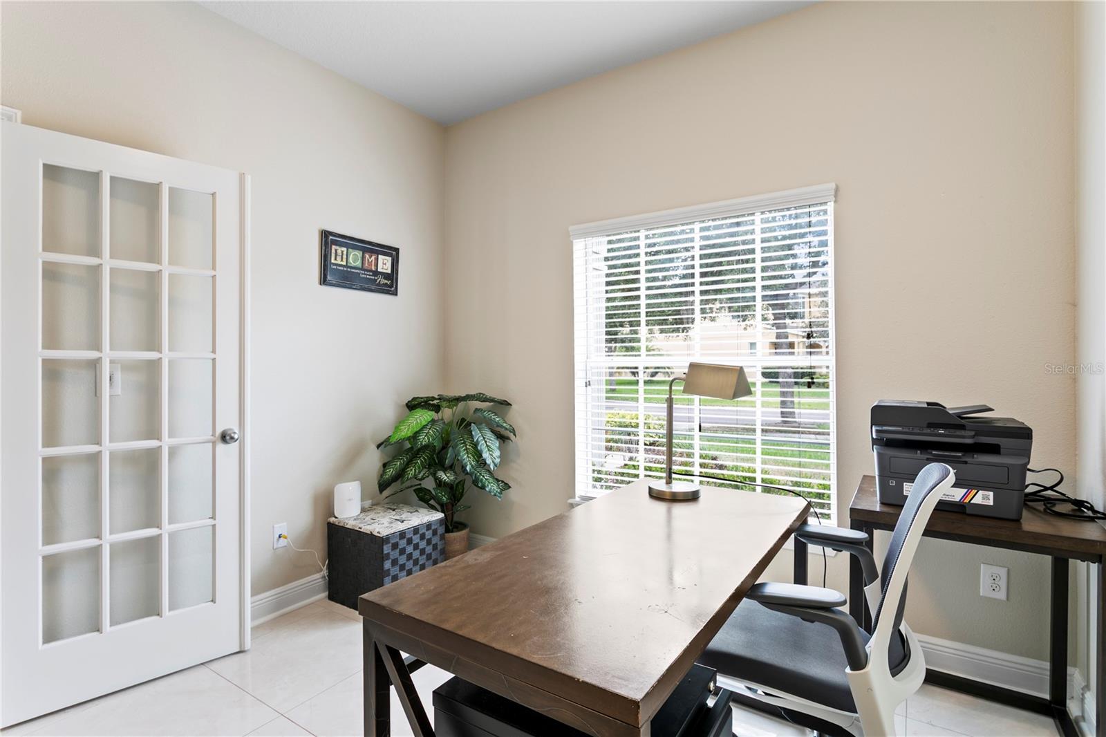 Office with large window overlooking front yard