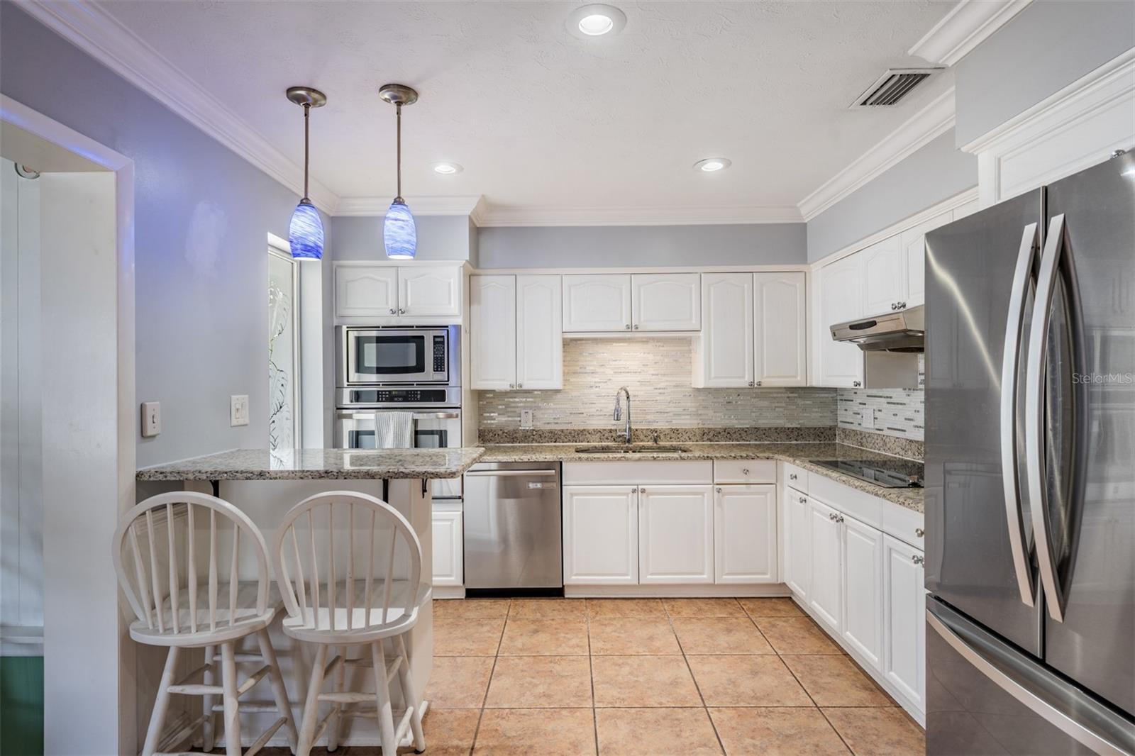 modernized light and bright kitchen featuring stainless appliances