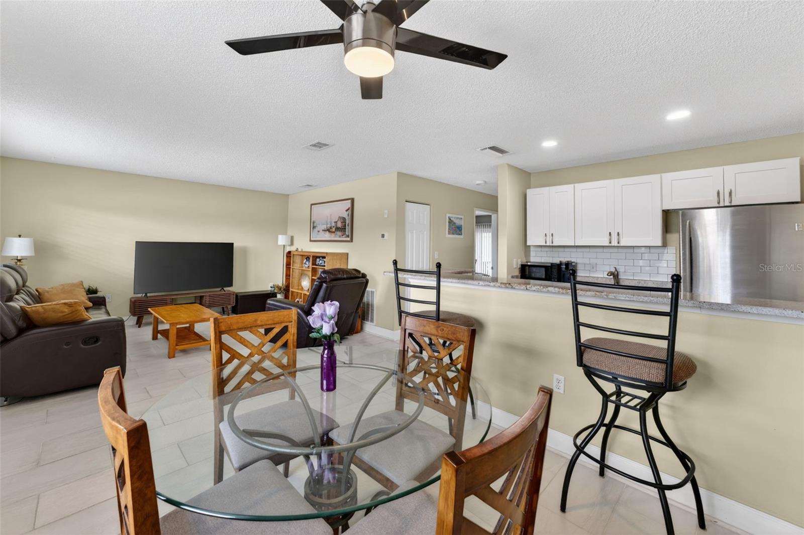 Open Concept remodelled Kitchen with Granite countertops, kitchen bar, shaker cabinets, recessed lighting and upgraded backsplash with stainless steel appliances.