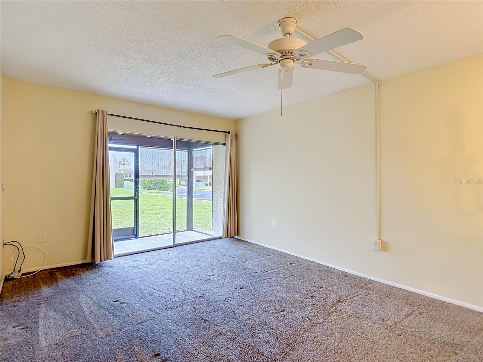 living room with sliders out to Florida room/ lanai