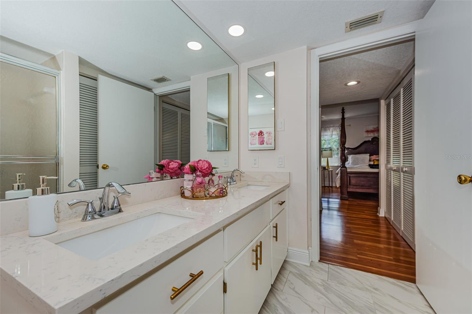Updated Master bath with dual sinks, recessed lighting, Quartz countertops, and Ceramic tile floors, along with Walk-in Shower