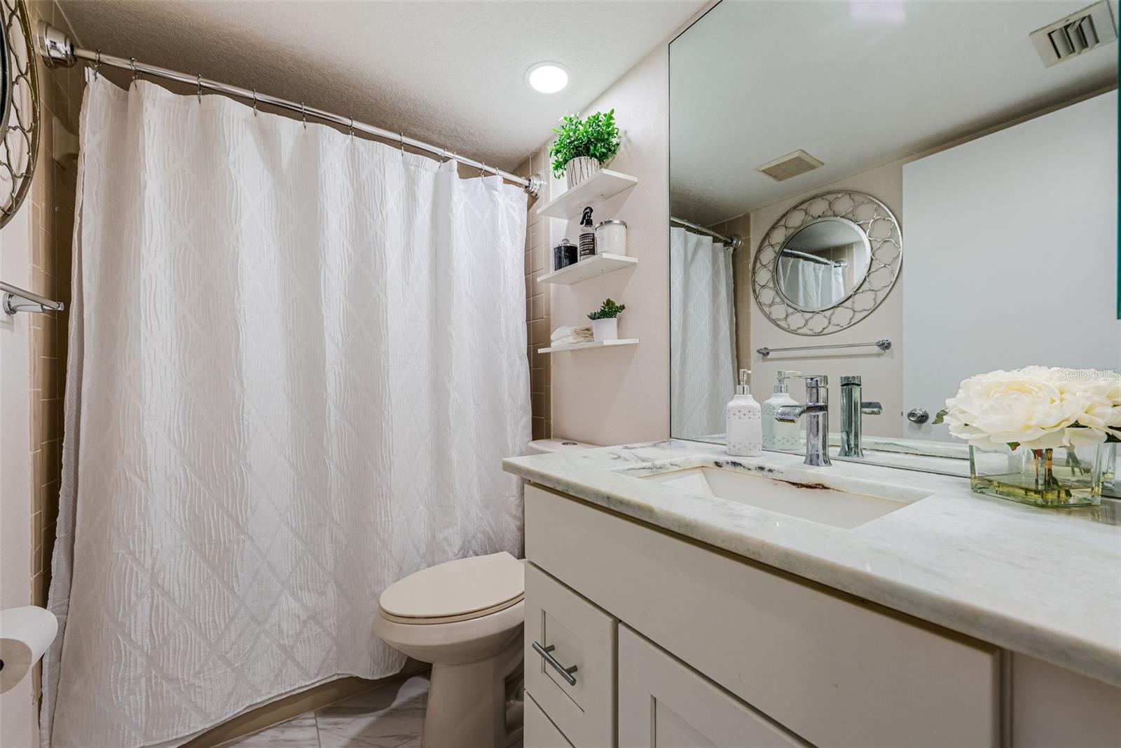 Updated Hall bath next to 2nd bedroom, Granite countertops, ceramic tile and shelves.