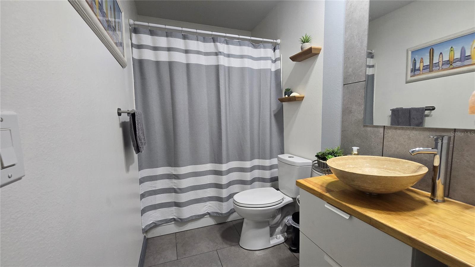 Guest bathroom offers an extended vanity, with storage options, linen closet, tub and shower.