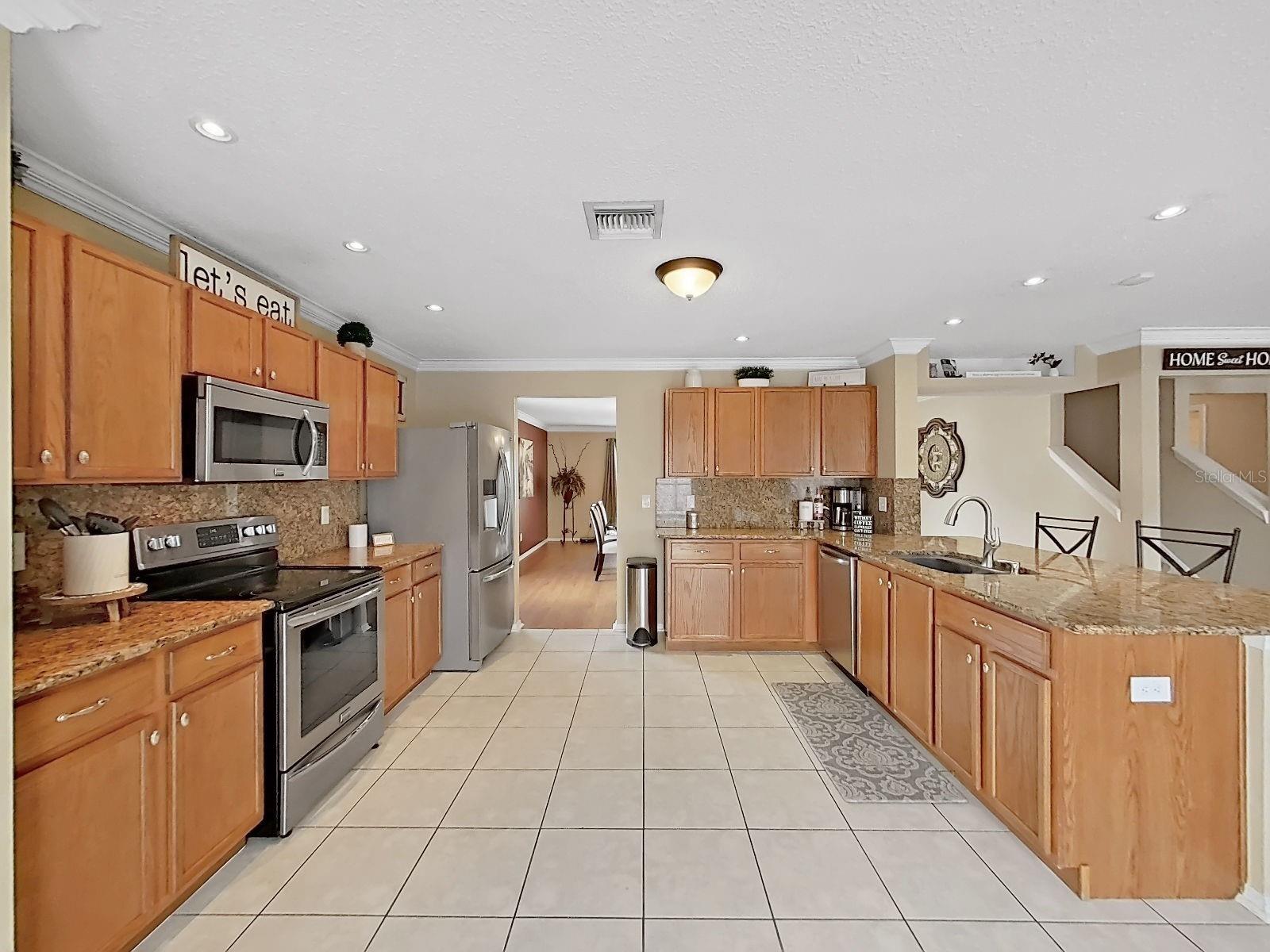 Expansive kitchen with granite counters & backsplash, stainless appliances, and cabinet space that goes on forever!