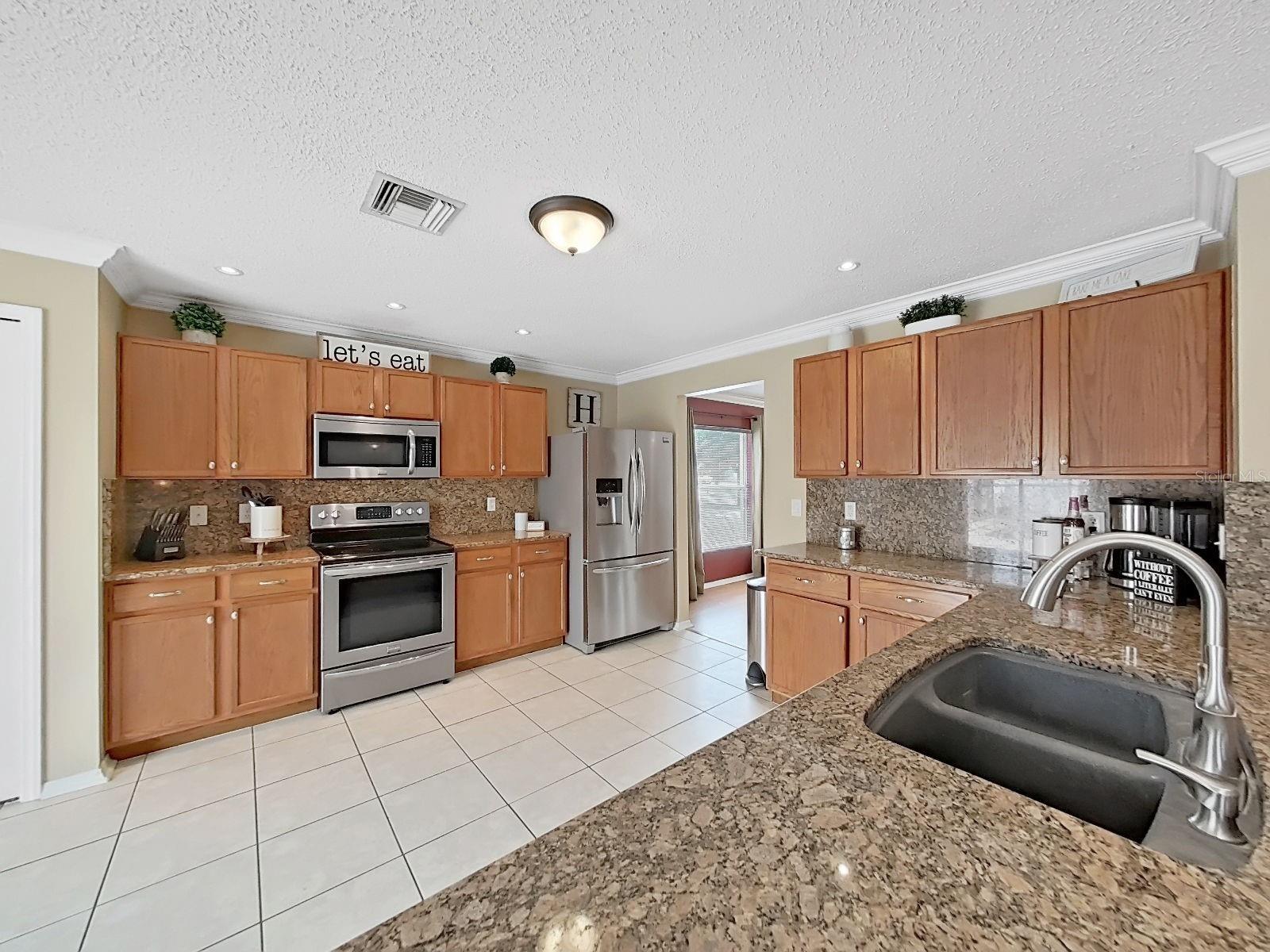 Light filled kitchen with stainless appliances and granite.