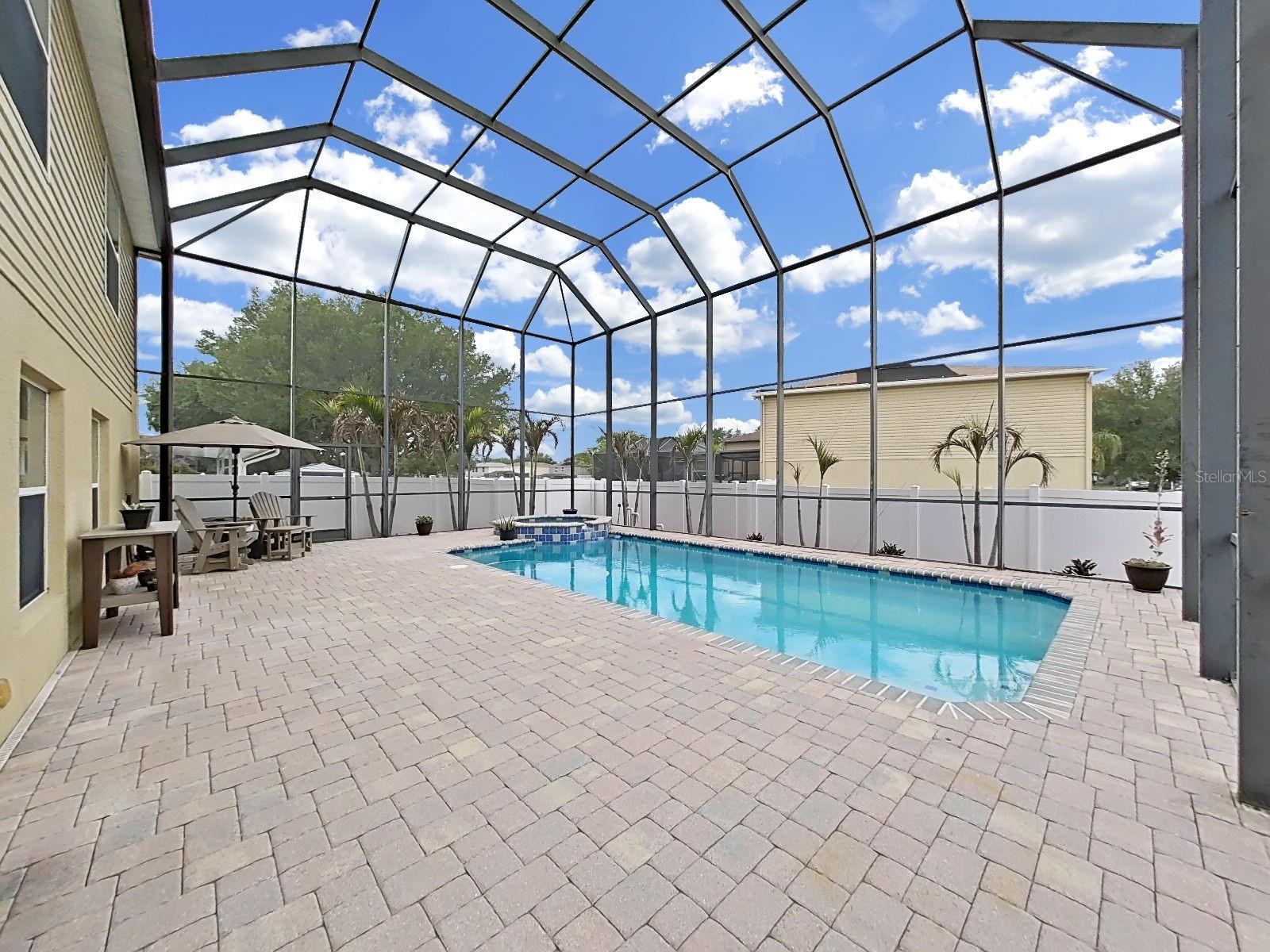 Sweeping paver pool deck, swaying palms, & a sparkling pool and spa, under a soaring screen enclosure with new screen. Your own private slice of Florida paradise!