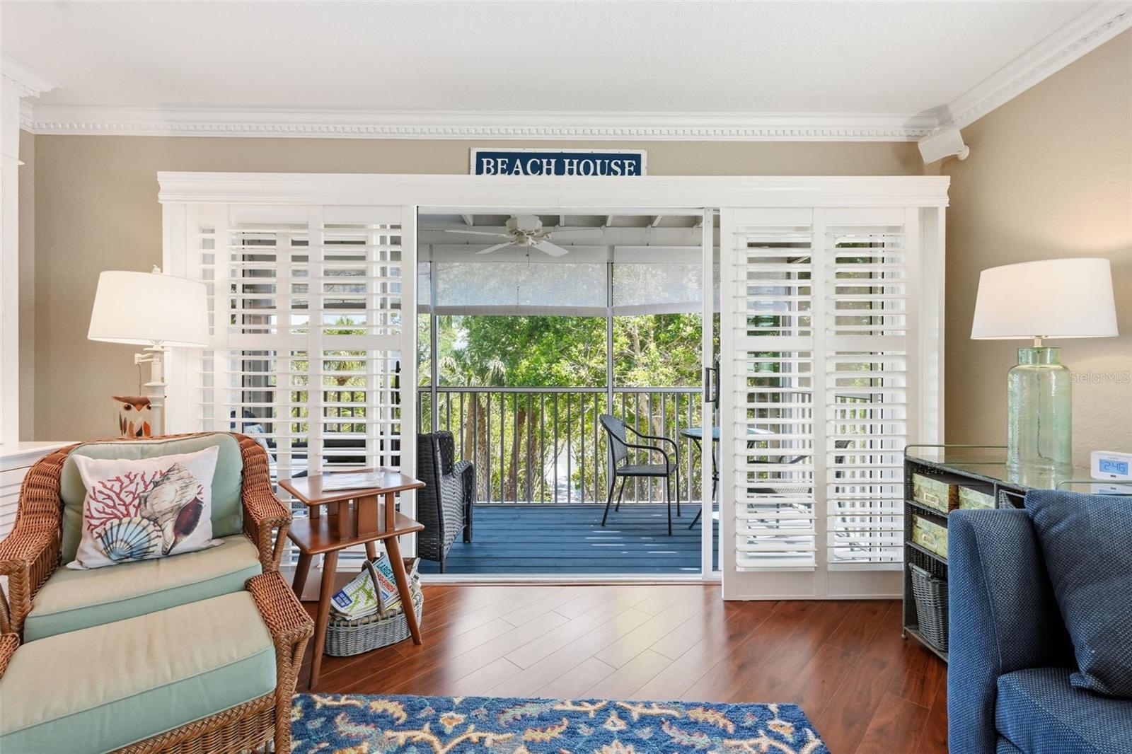 Sliding Plantation Doors to the screened patio overlooking a tranquil green space and the water.