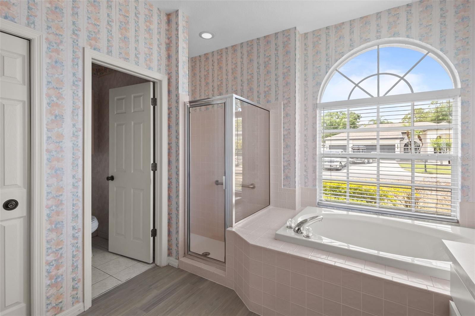 Primary bathroom with dual sinks, soaking tub, and separate shower.