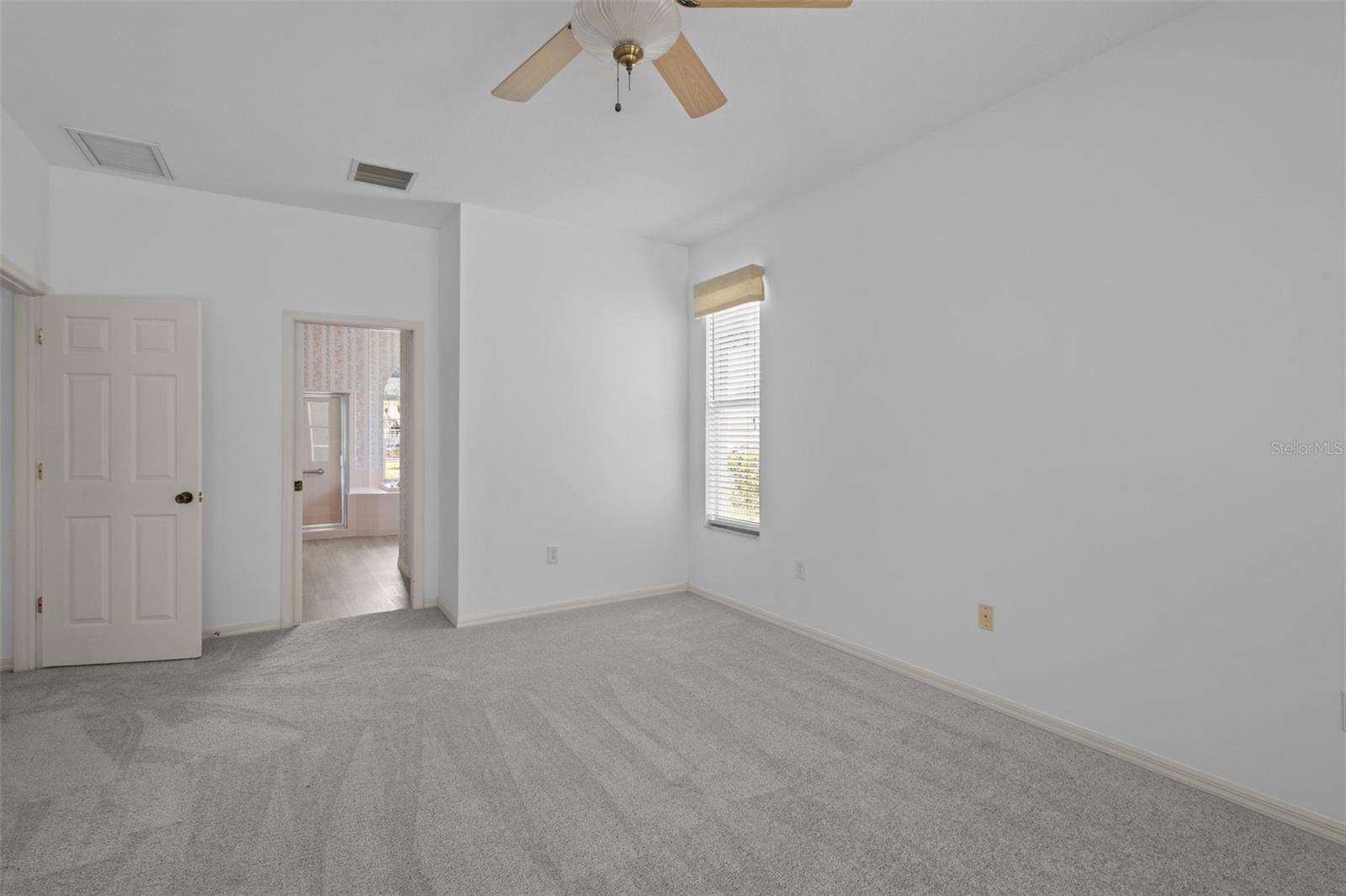 Primary suite located off the main living area with direct pool access.