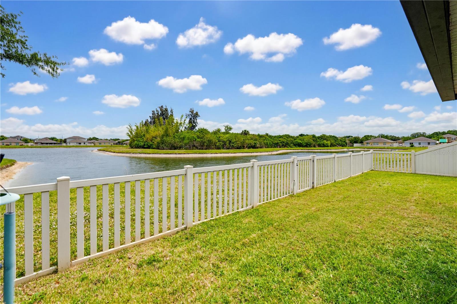 Fenced backyard with a view of the pond
