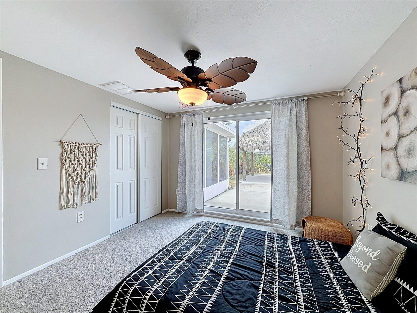 Bedroom 1 with sliding glass door to the paved patio and Tiki Hut