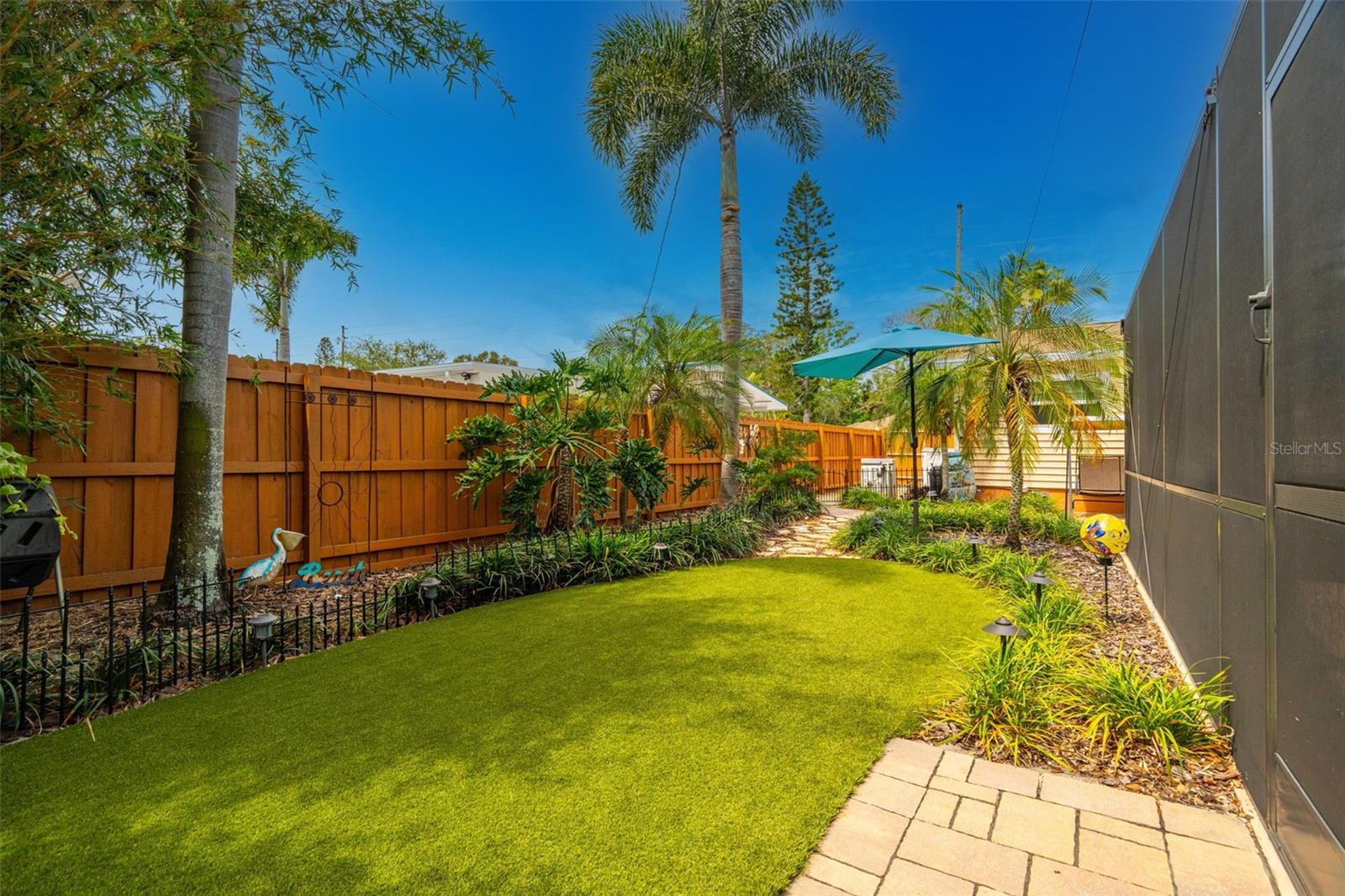 The grounds have been thoughtfully curated with pavered paths, multiple sitting areas, and lush tropical landscaping.