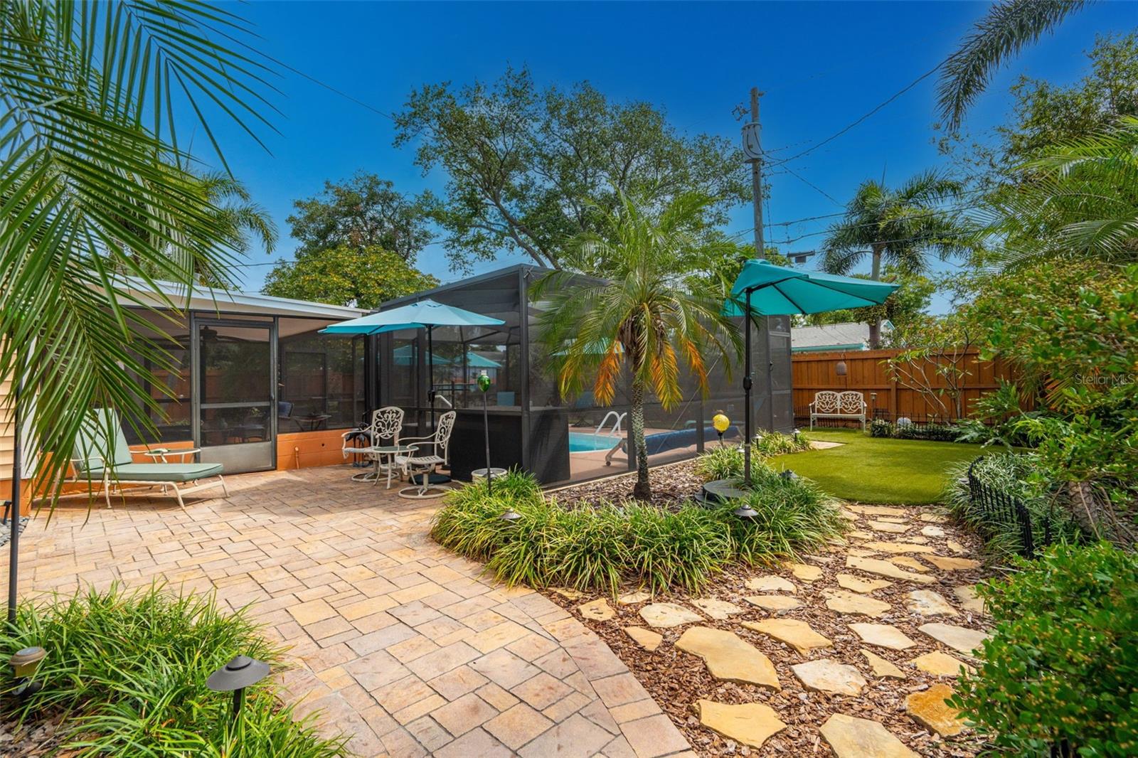 The grounds have been thoughtfully curated with pavered paths, multiple sitting areas, and lush tropical landscaping.