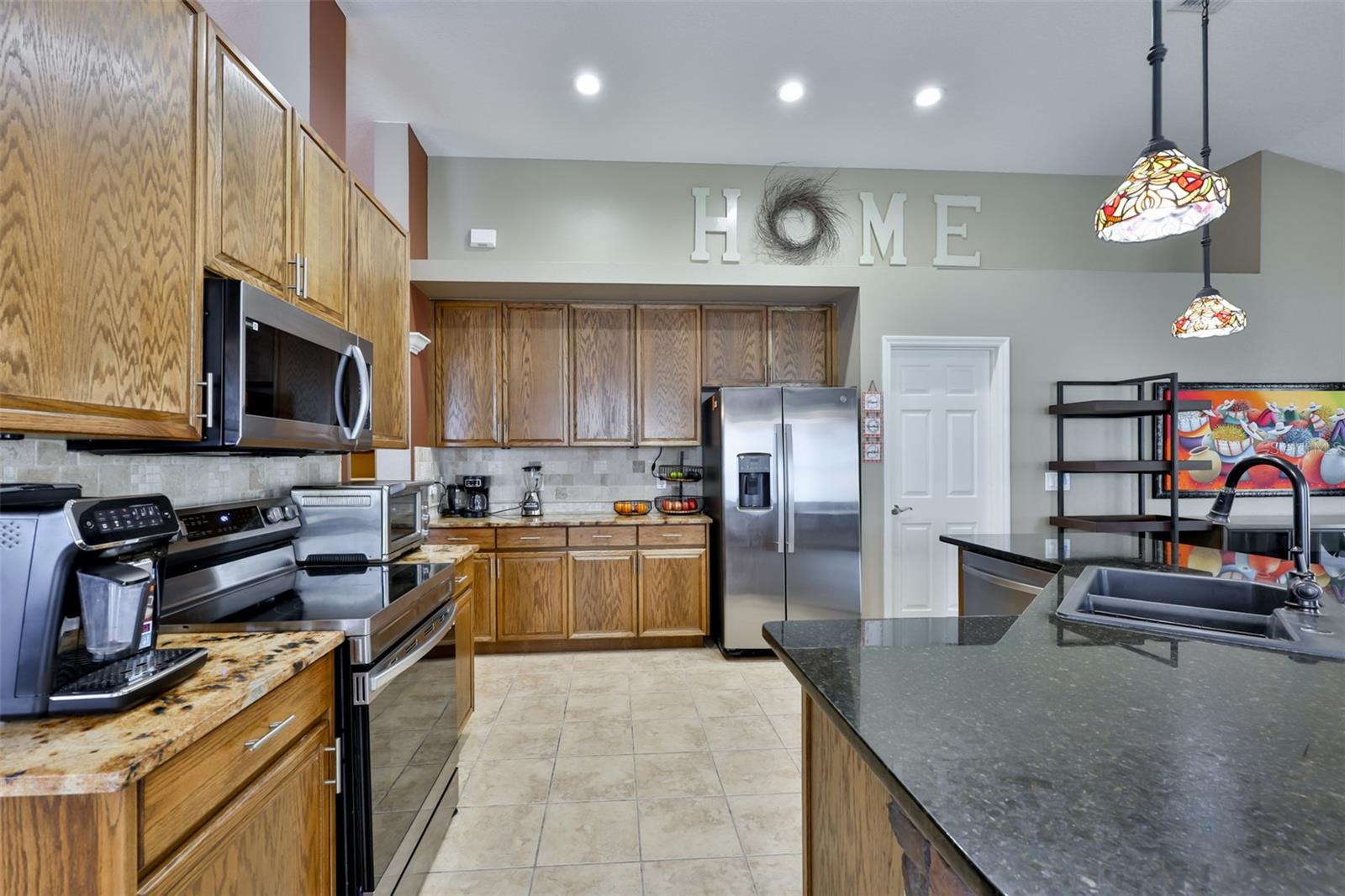 Lots of cabinet and counter space and the door to the right of the refrigerator is the large walk-in pantry.