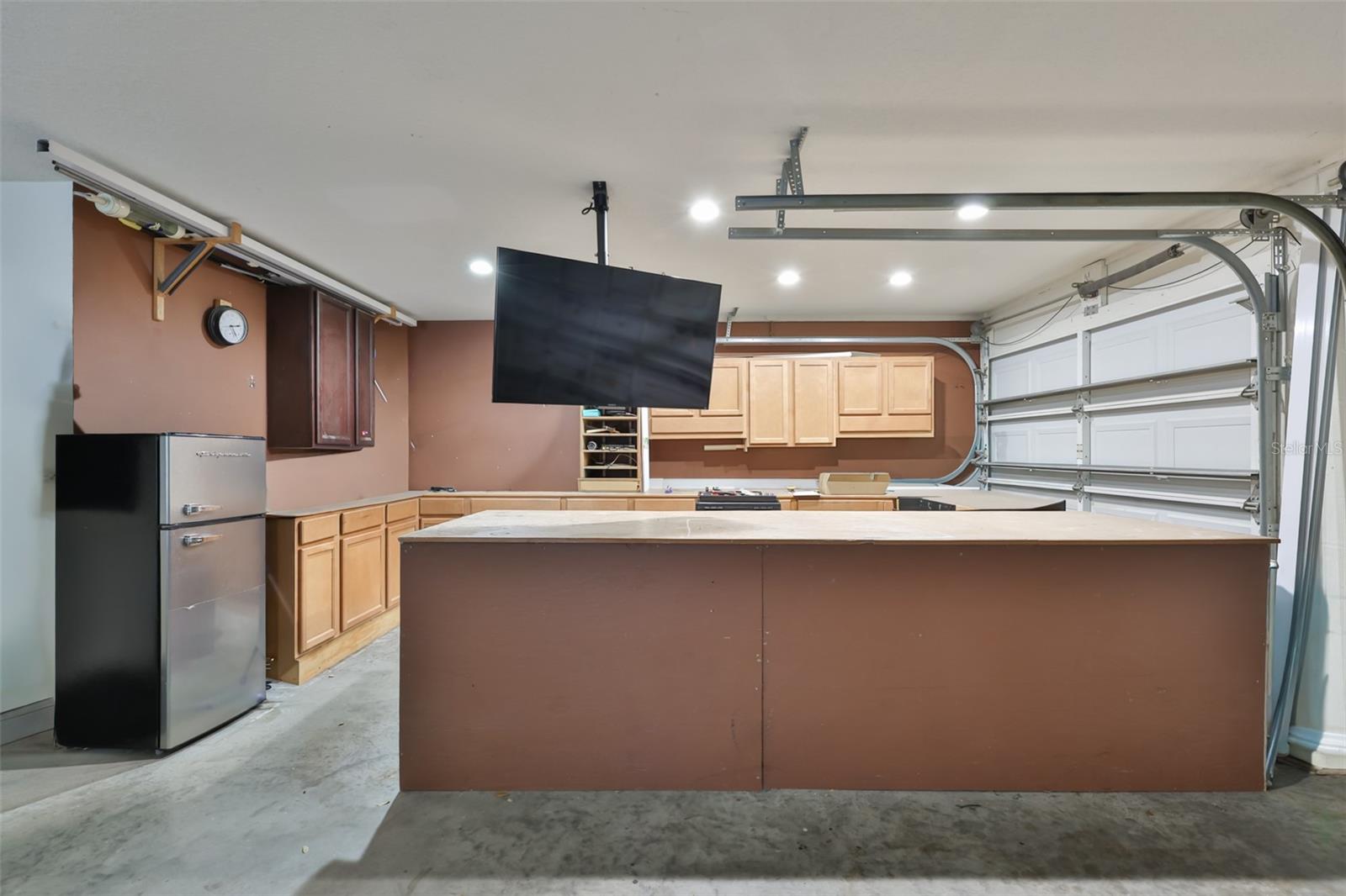 3rd Bay of garage has workshop with ample storage closets and the TV conveys! Watch the game or a tutorial while getting a project done!