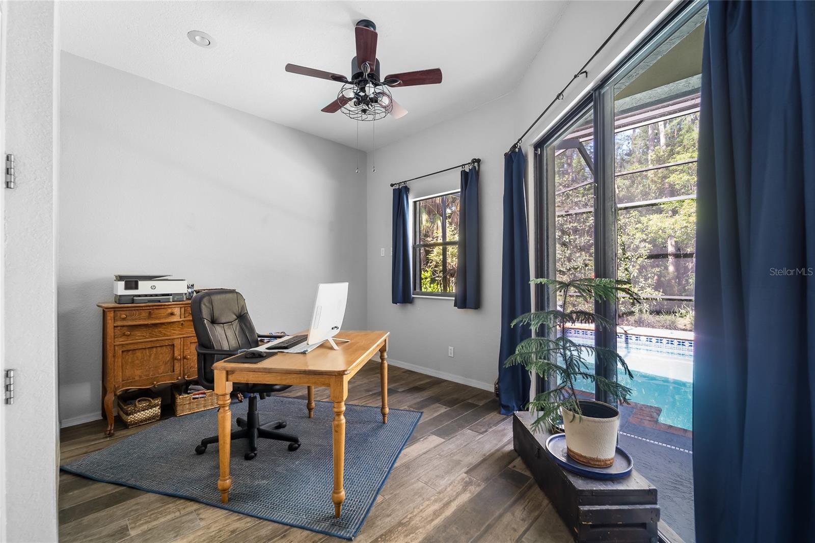 separate office attached to primary bedroom with sliders to pool area