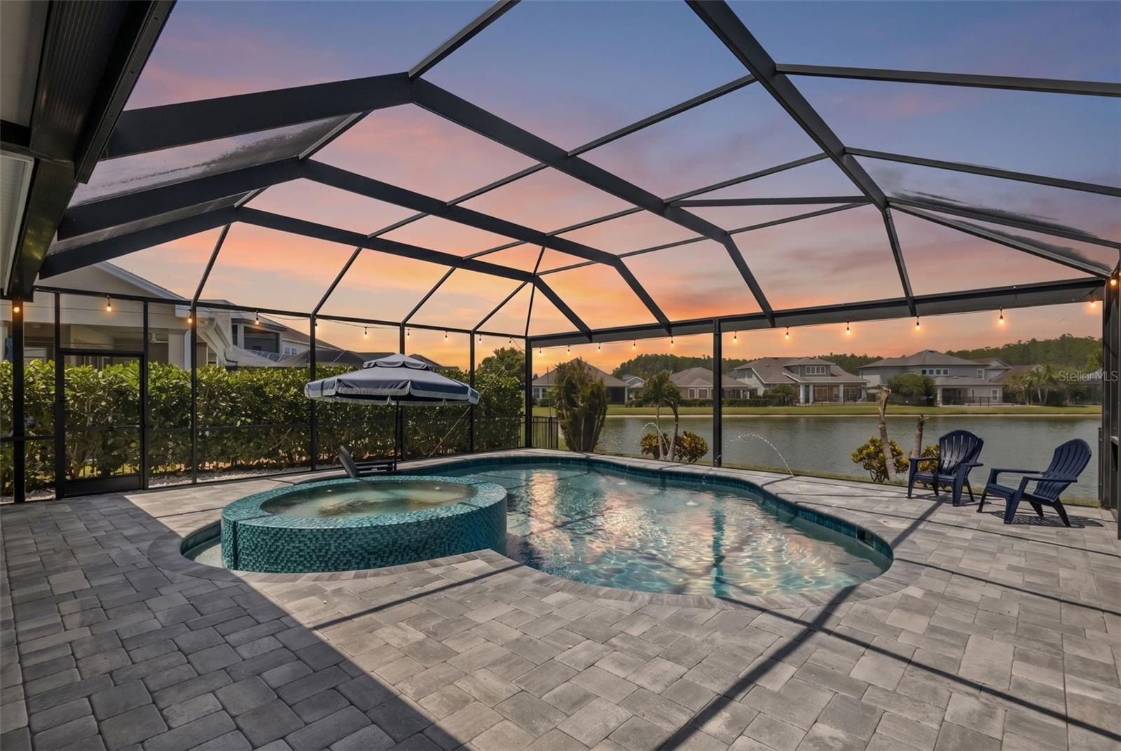 Gas-heated pool with infinity-edge spa, sunshelf, and water features, all overlooking a tranquil pond. Fenced side yard with tropical landscaping.