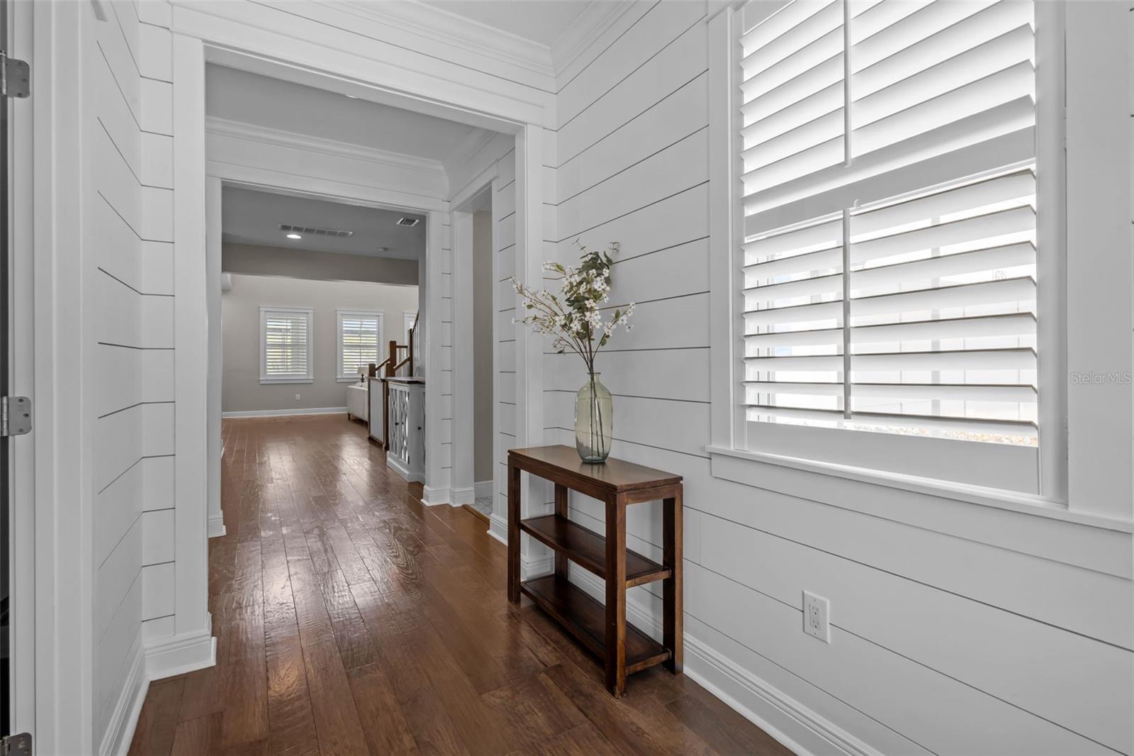 Welcoming entry with shiplap detailing, crown molding, and abundant natural light.