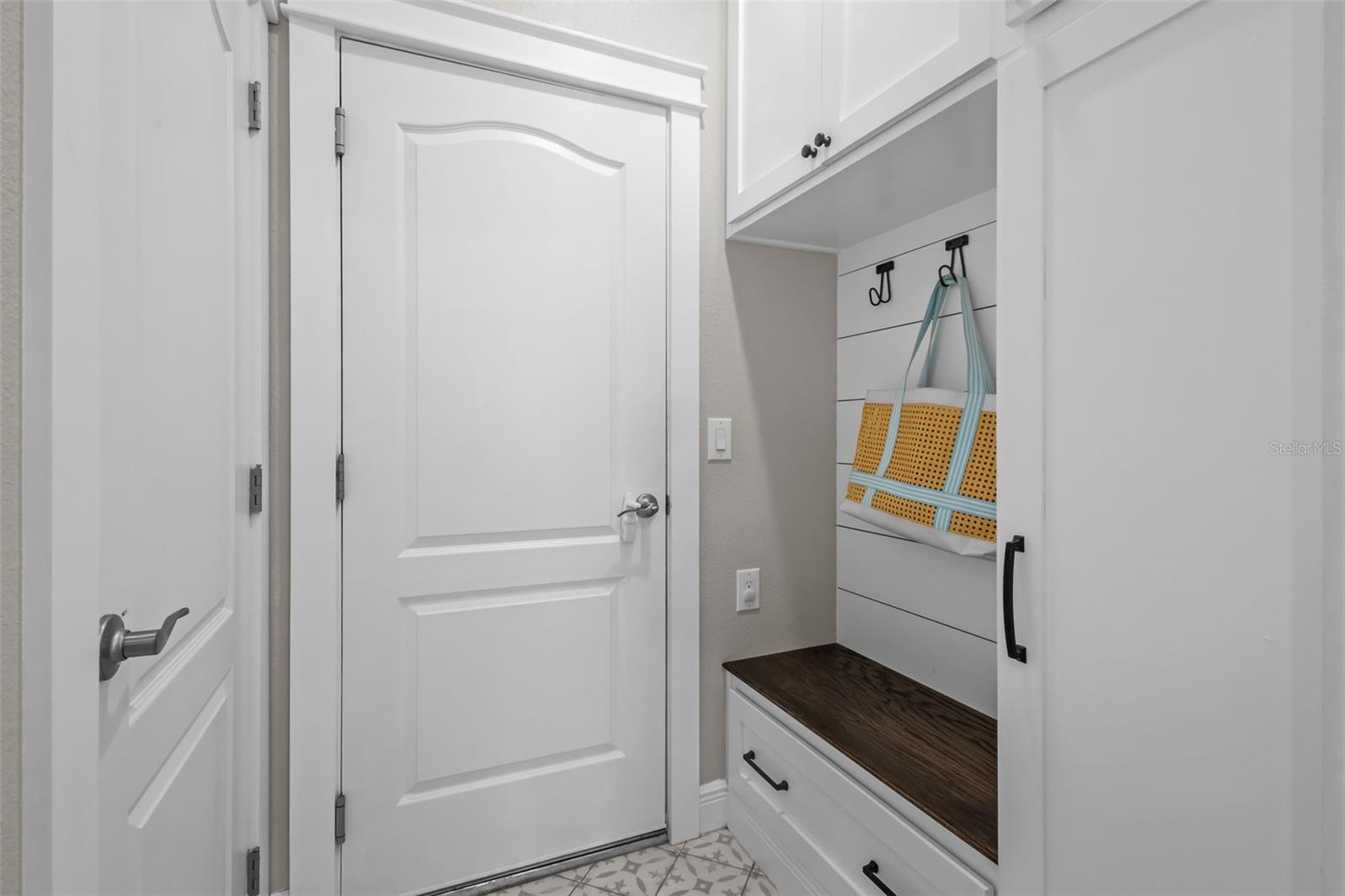 Functional drop zone with built-in storage cabinetry and designer tile flooring.