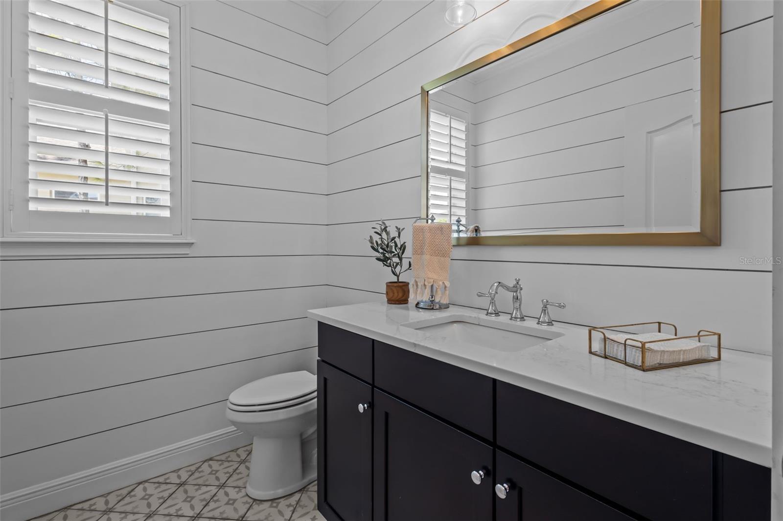 Main level powder room with quartz countertops and upgraded finishes.