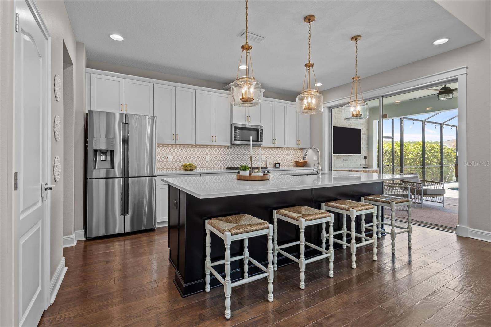 Updated in 2022 with quartz countertops, custom backsplash, gold hardware, pendant lighting, and under-cabinet lighting.