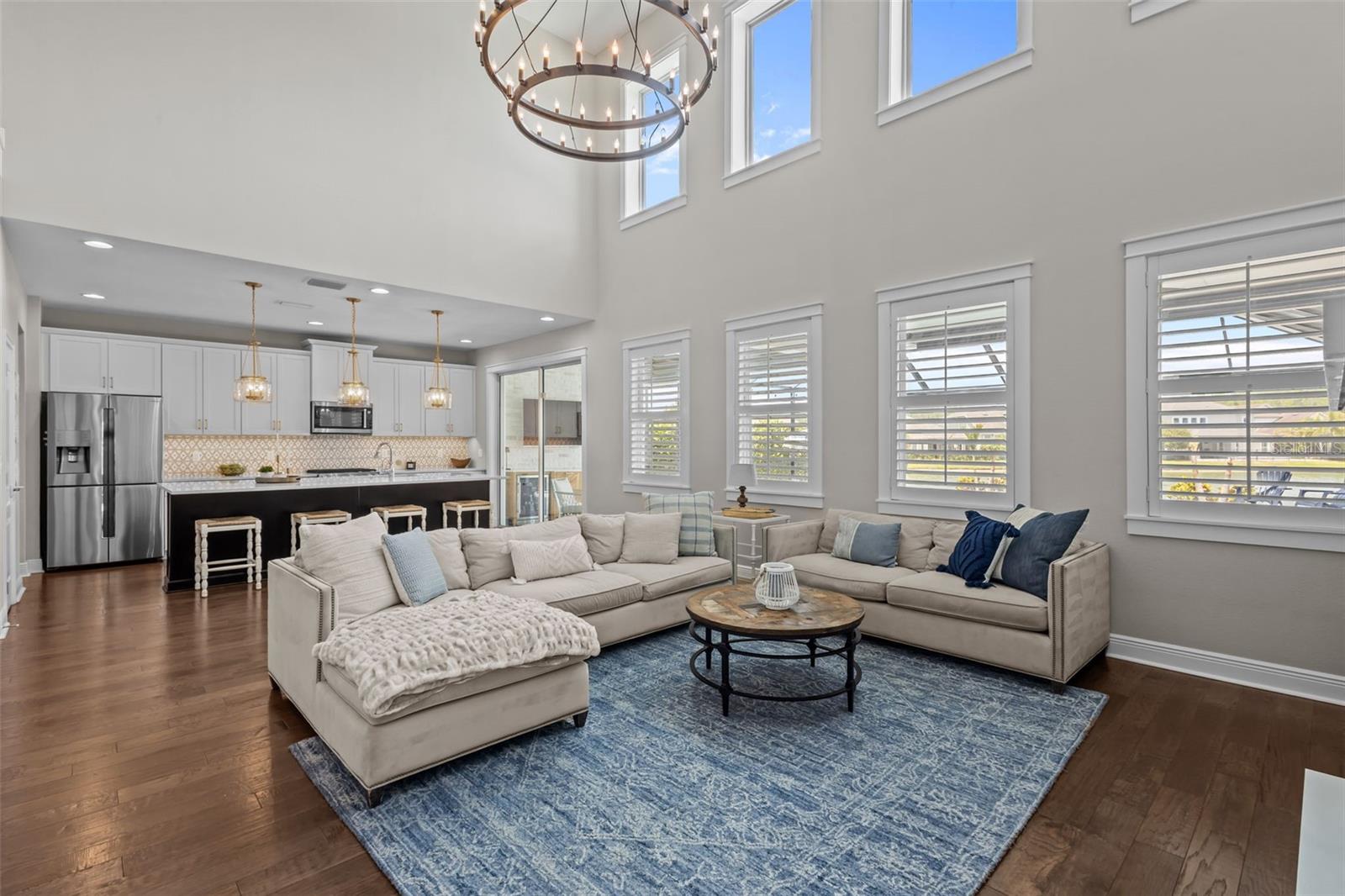 Two-story ceilings, a floor-to-ceiling fireplace, and built-in cabinetry create a bright, open focal point.