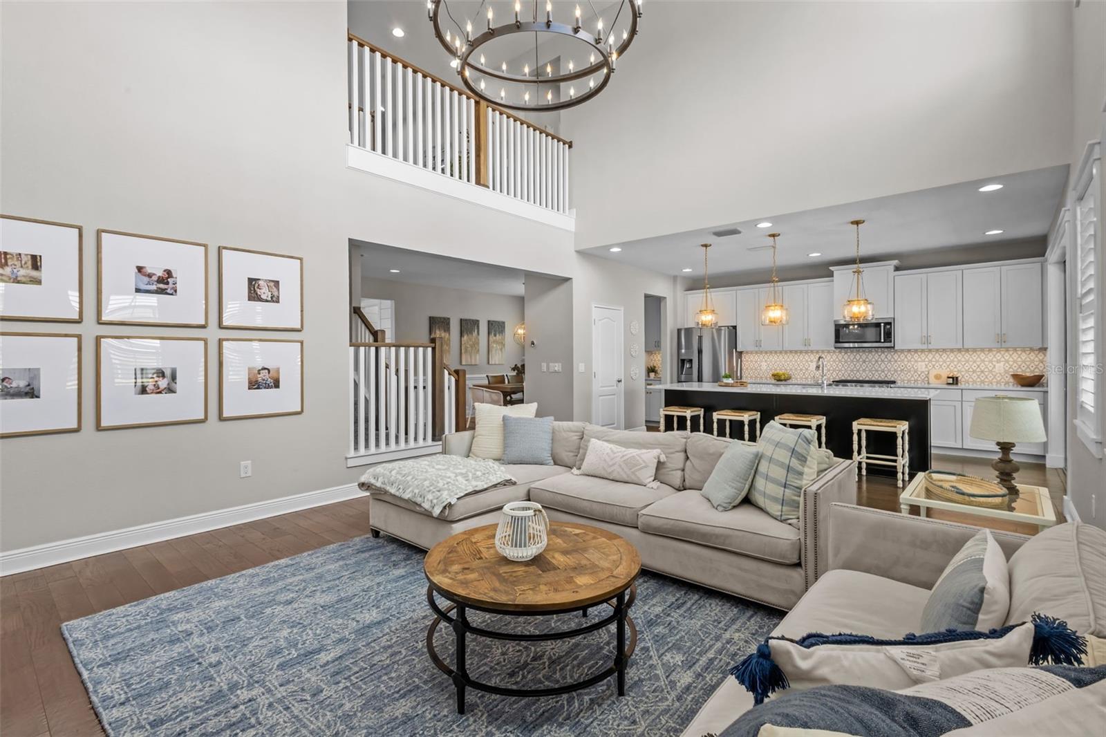 Two-story ceilings, a floor-to-ceiling fireplace, and built-in cabinetry create a bright, open focal point.