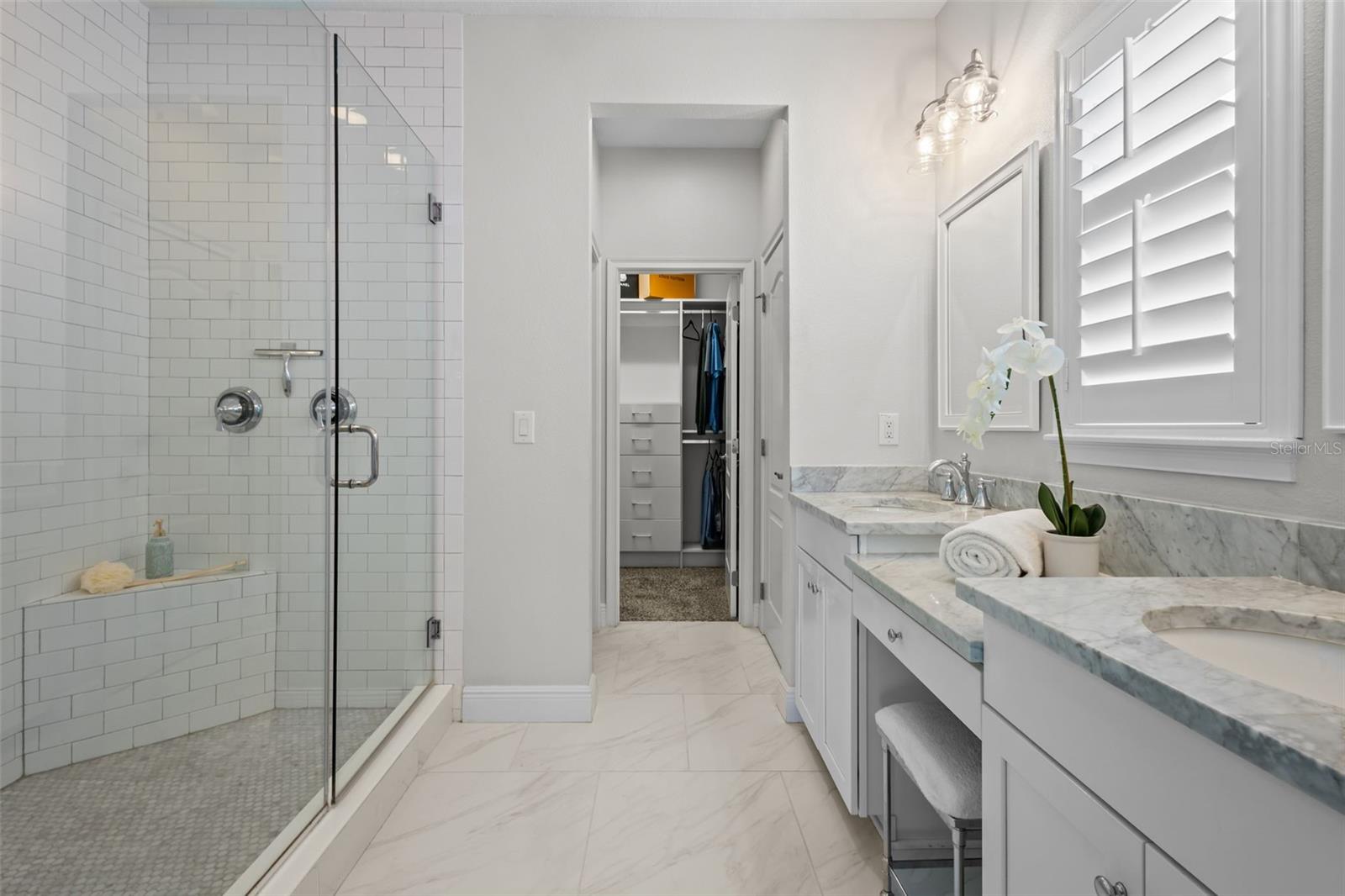 Marble countertops, dual sinks, and a walk-in shower with dual showerheads.