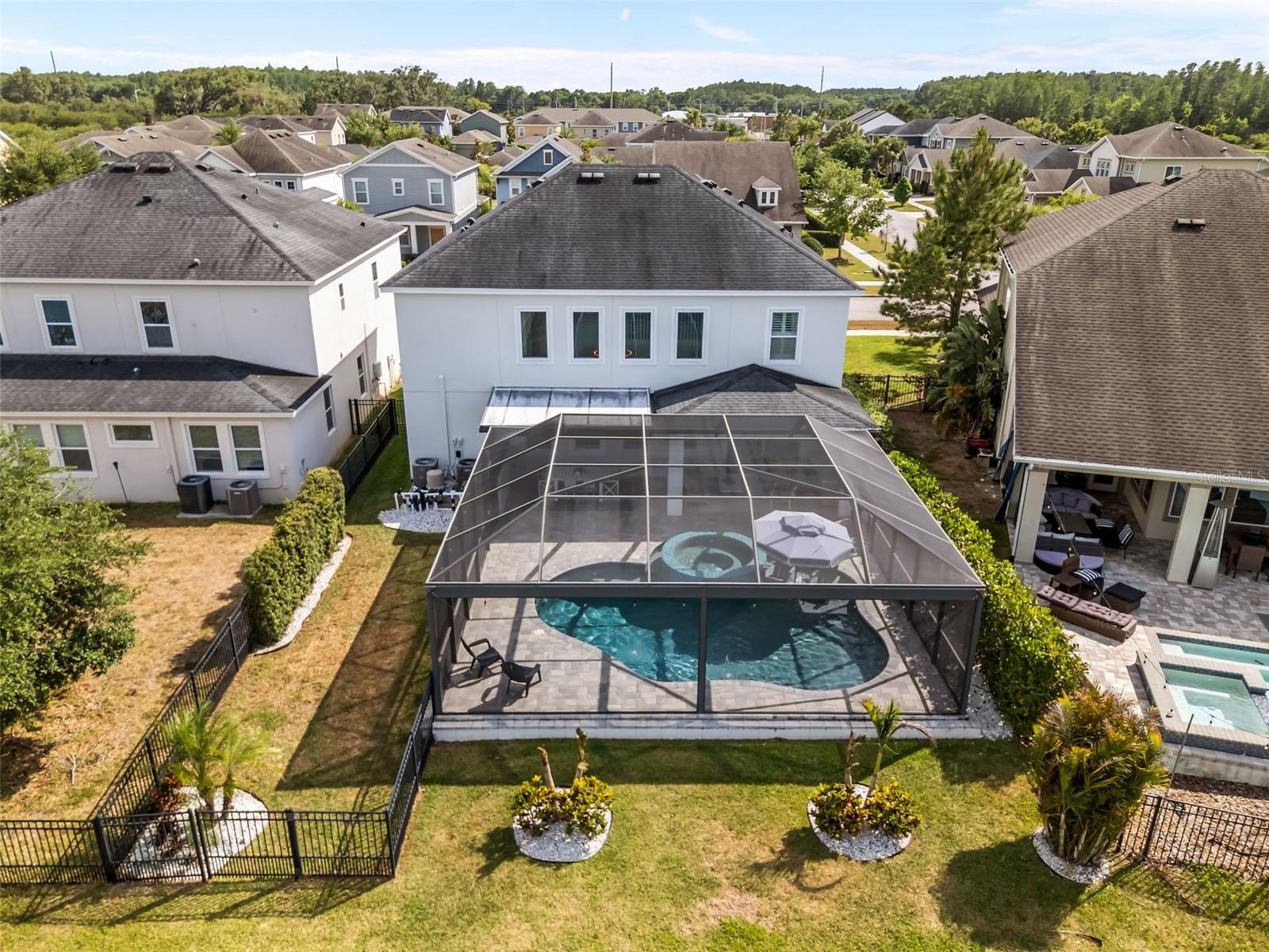 Fully screened lanai overlooking the water, with covered seating and a seamless indoor-outdoor connection.