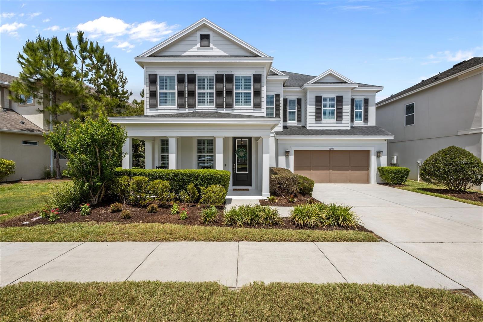 Classic white exterior with black shutters and a covered front porch—clean, timeless curb appeal with a welcoming presence.