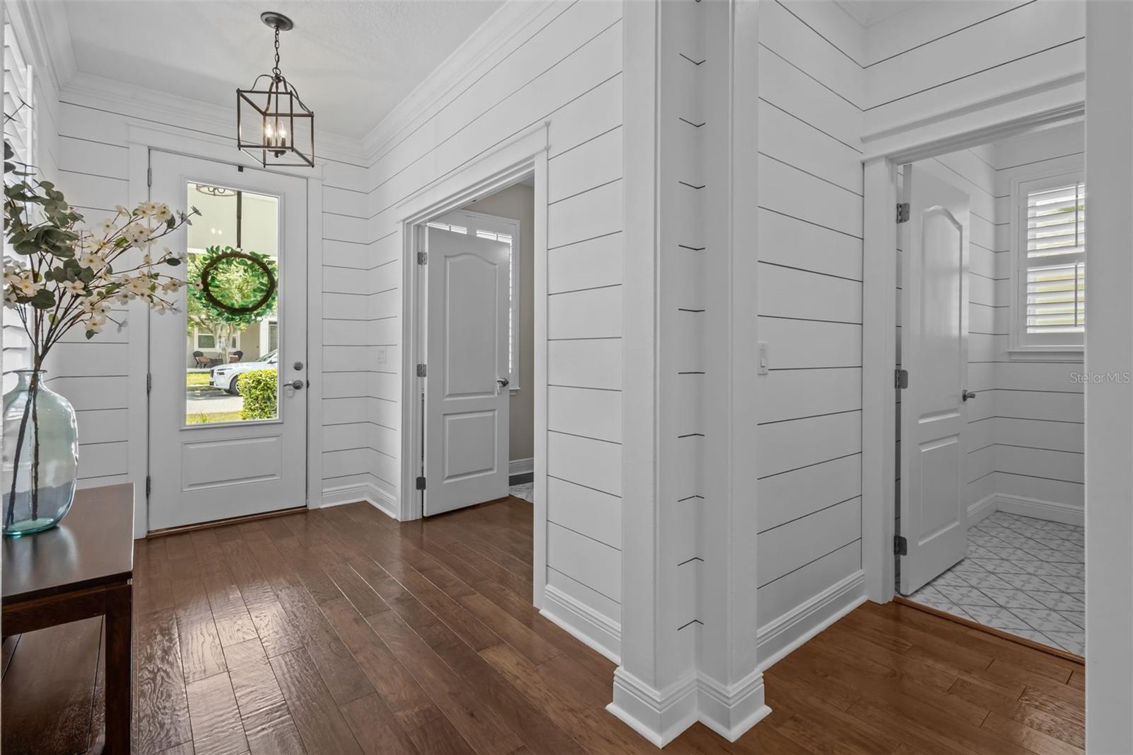 Welcoming entry with shiplap detailing, crown molding, and abundant natural light.