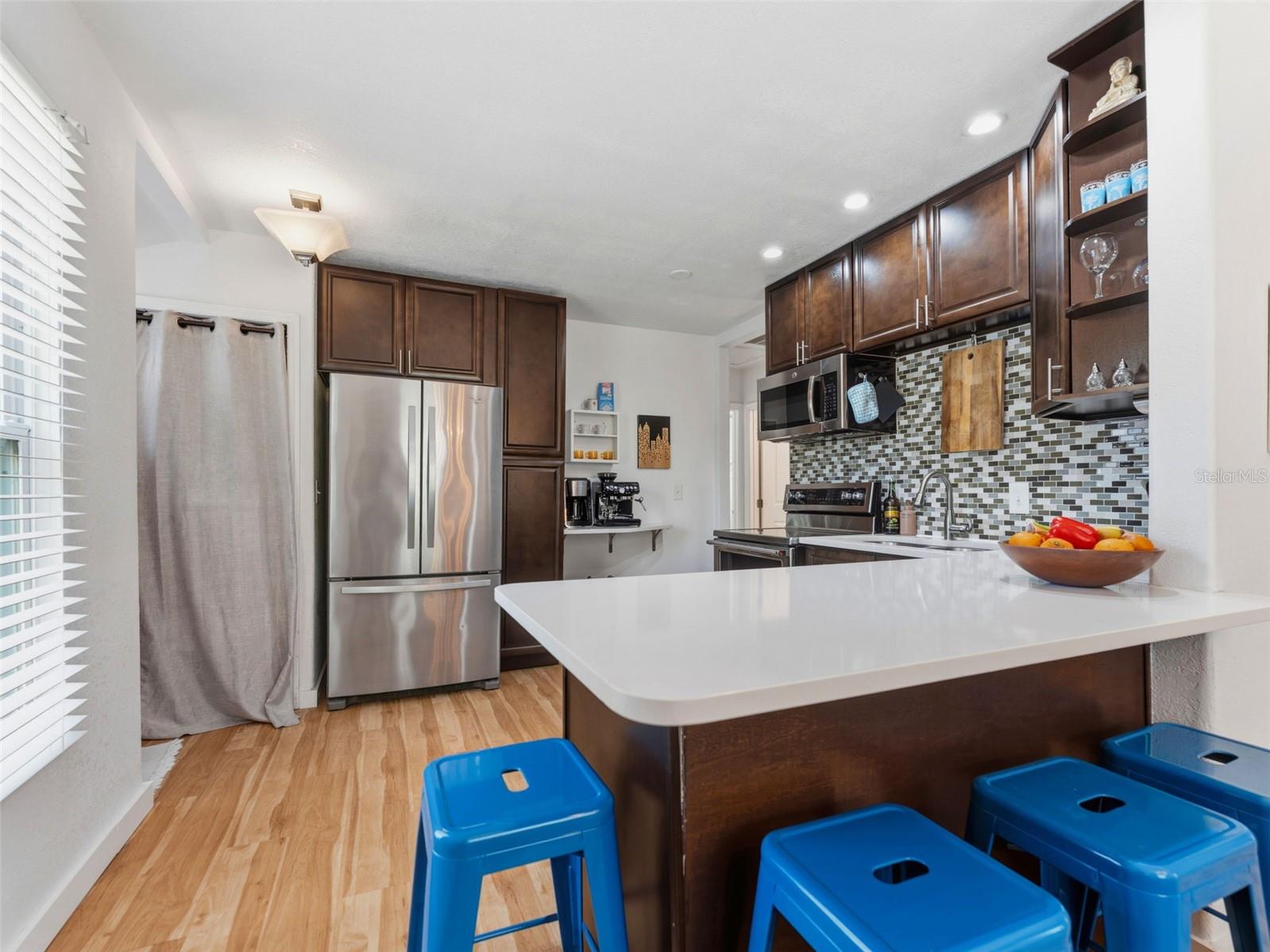 New counters and sink, washer and dryer are beside the refrigerator