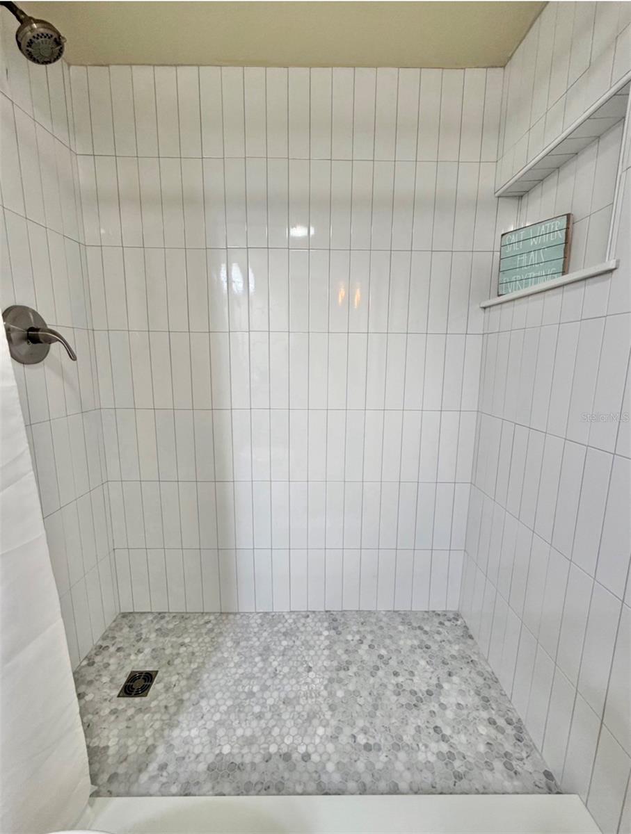 The brand new walk-in shower has new fixtures and a niche too!