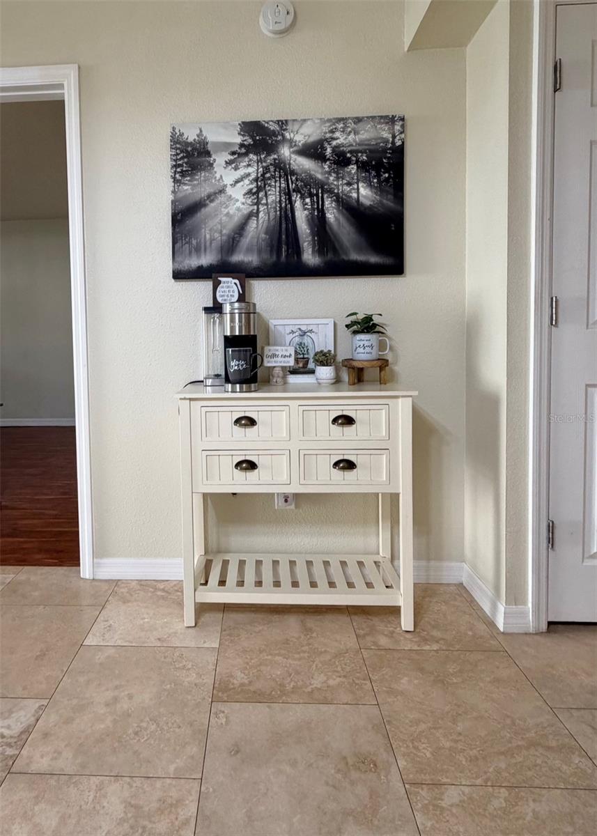 Travertine floors are throughout the living room and the kitchen and hallways. The coffee bar could stay if a buyer desired.