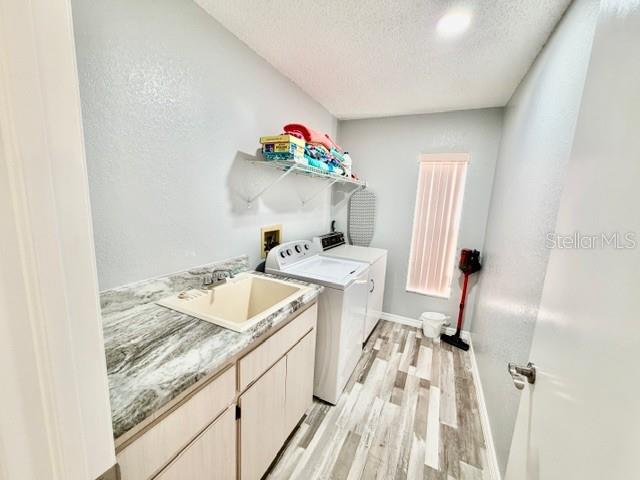 laundry room with granite counter top, sehlf and wash sink