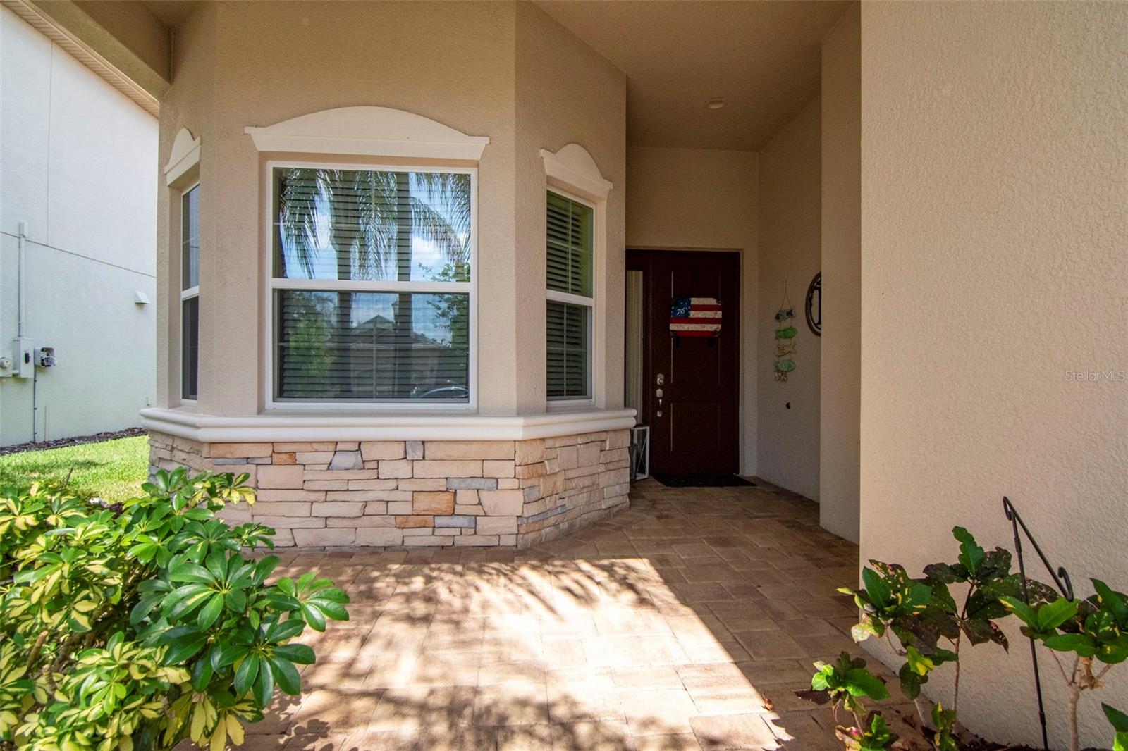 Charming paver front porch complemented by a stone accent wall