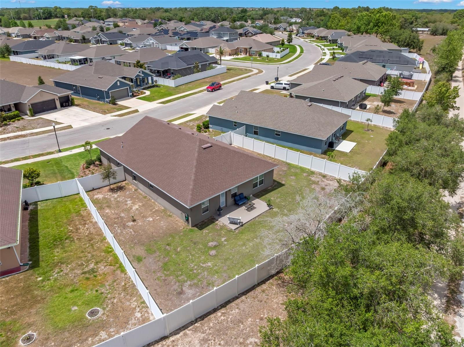 Privately situated against a wooded backdrop, the expansive fenced yard provides room to spread out and enjoy the outdoors.