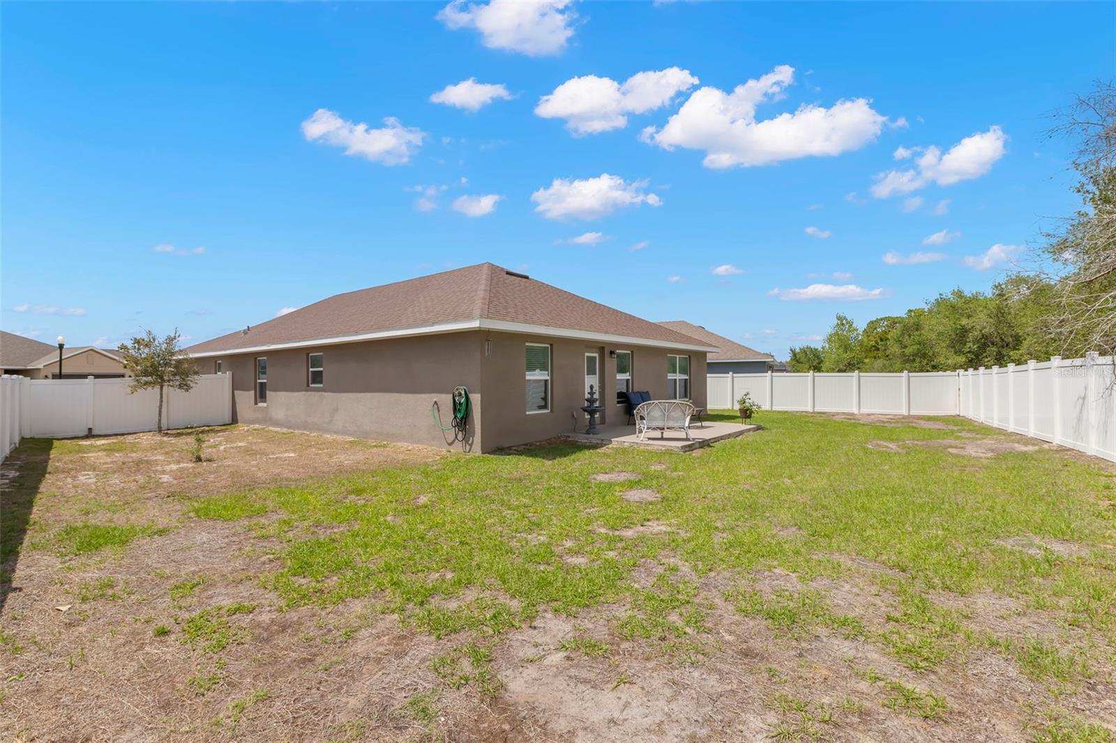 The oversized vinyl-fenced backyard offers abundant open green space, an expansive side yard, and endless flexibility for pets, play, gardening, or future outdoor enhancements.