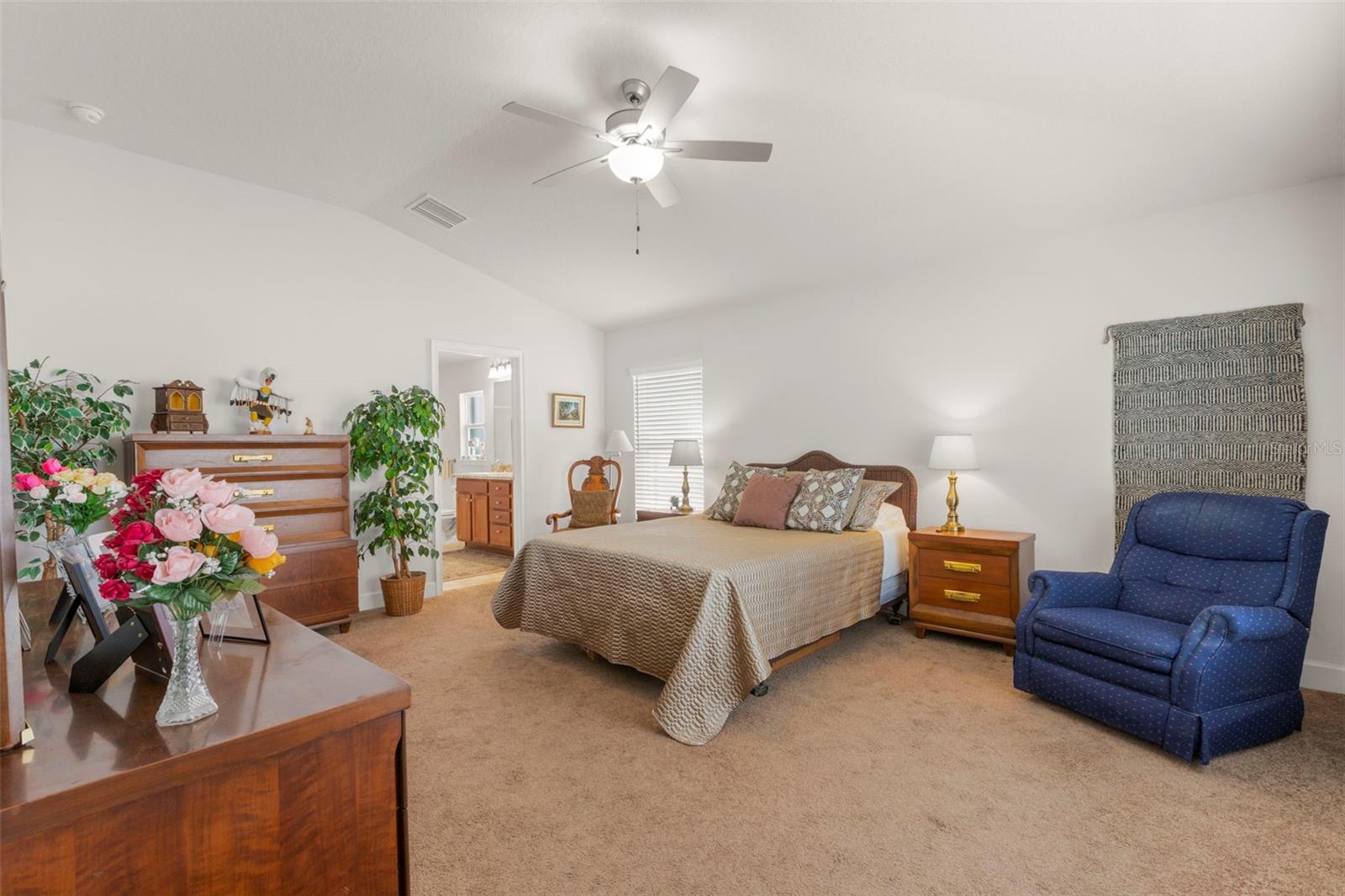 Vaulted ceilings and expansive dimensions enhance the spacious primary suite, offering flexibility for both traditional bedroom furnishings and a private sitting area.