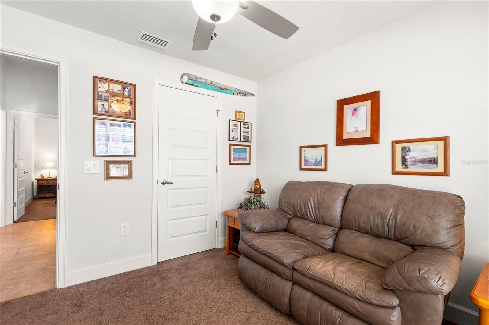 Bedroom 2 features a neutral color palette, a ceiling fan with light kit and a built-in closet.