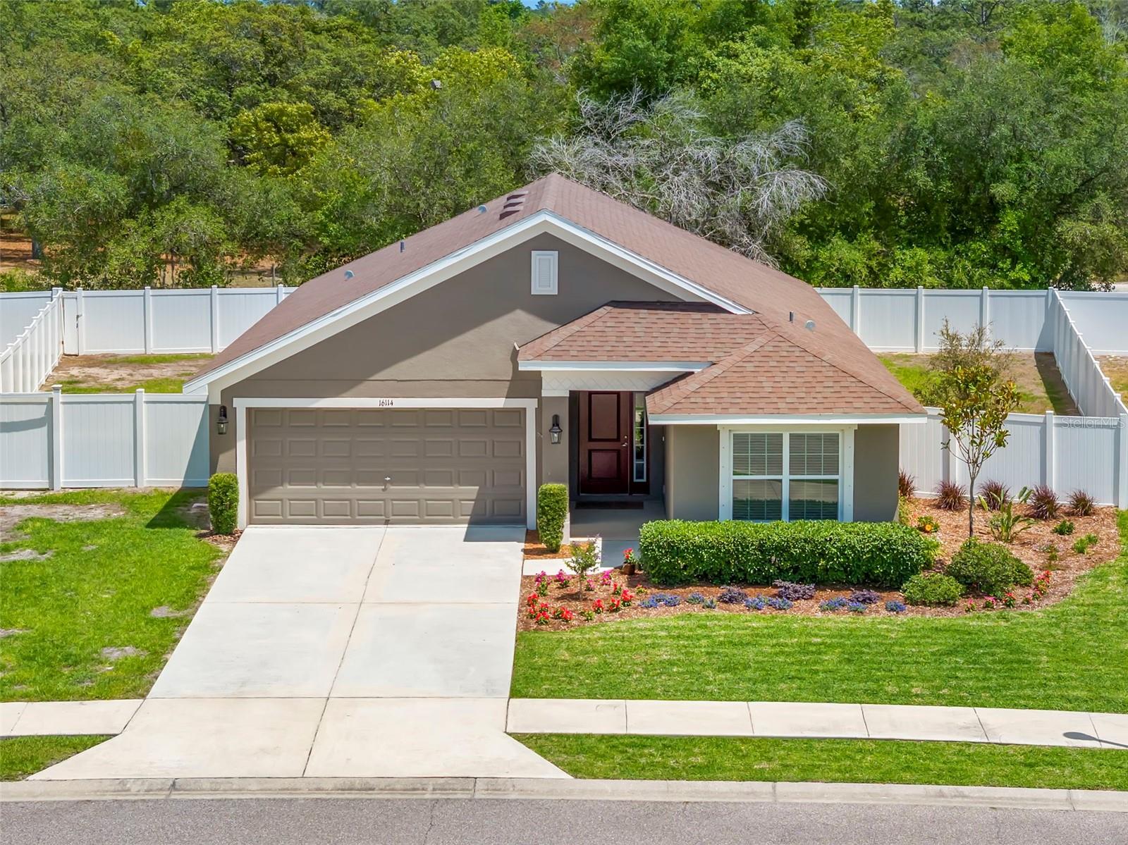 Bird’s-eye view showcases the home’s premium lot placement, expansive fenced yard, and private wooded backdrop.