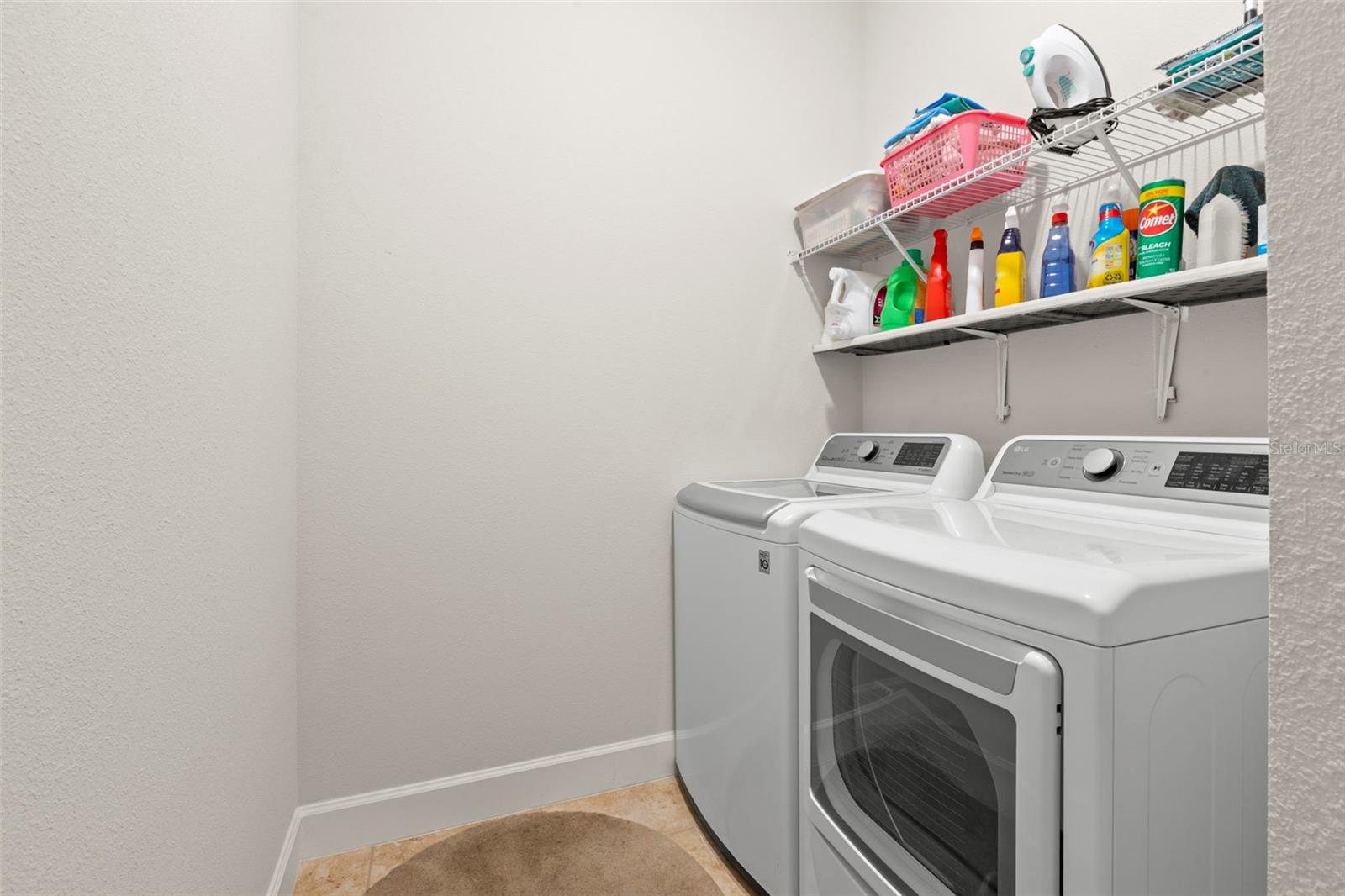 A dedicated interior laundry room with washer/dryer, adds everyday convenience with built-in shelving for storage and organization.