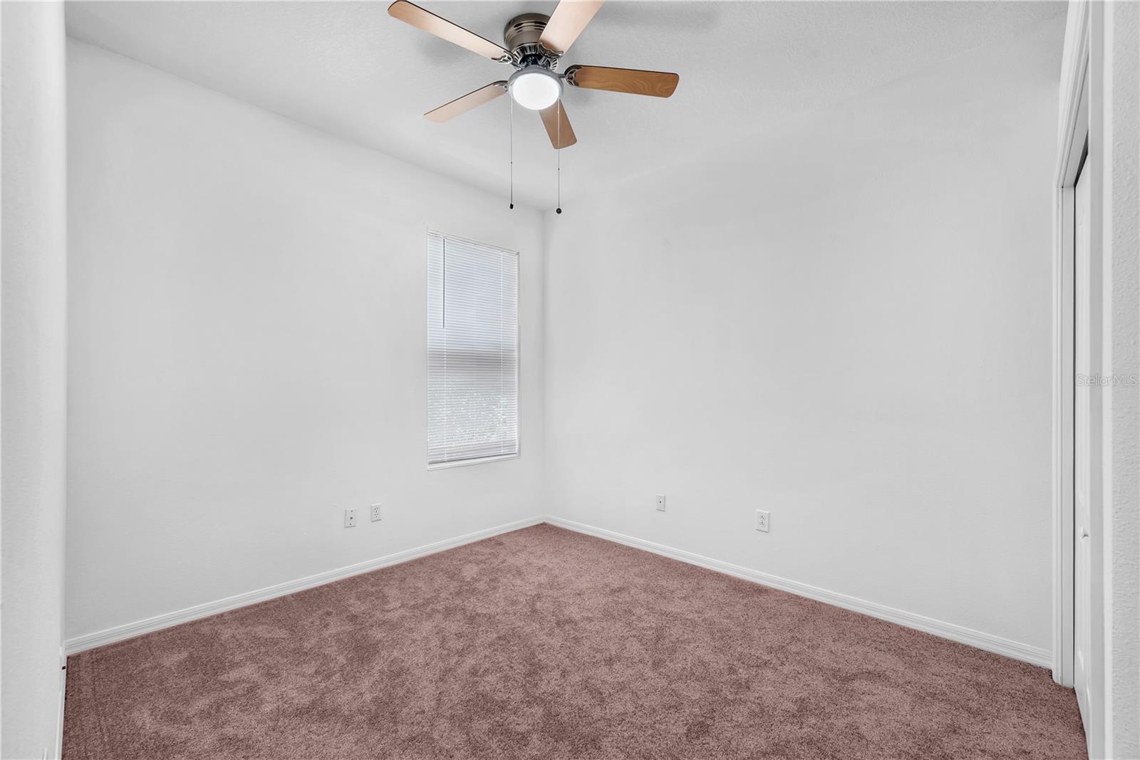 Secondary bedroom #2 with built-in closet, carpet and ceiling fan is 10' x 13'