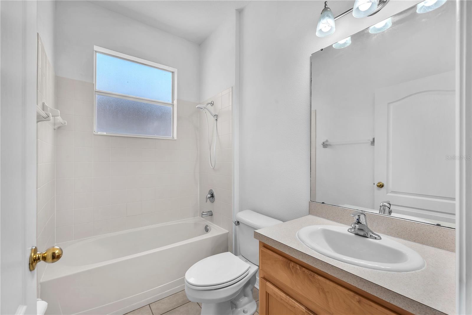 The guest bathroom has a bath tub/ shower combination.