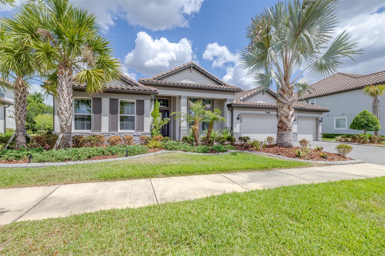 Mature Landscaping and Barrel-Tile Roof Accent the Exterior of the Home