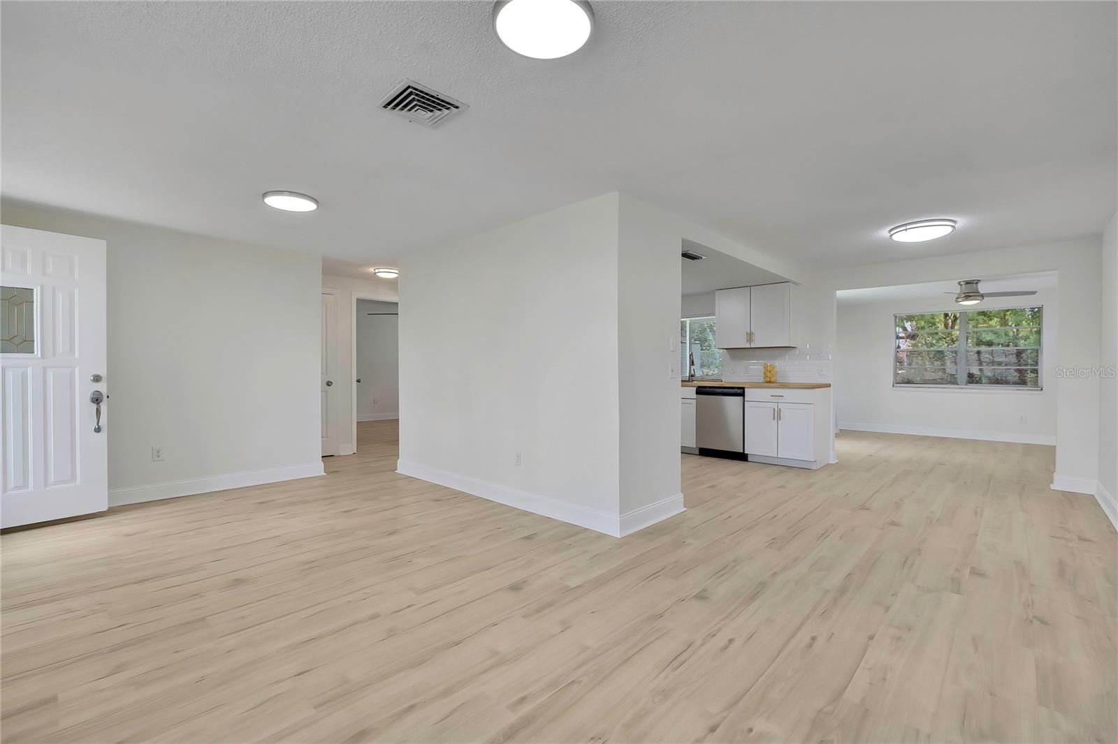 LIVING ROOM WITH KITCHEN VIEW/DINING ROOM and FLEX ROOM IN THE REAR WITH SLIDER DOORS.