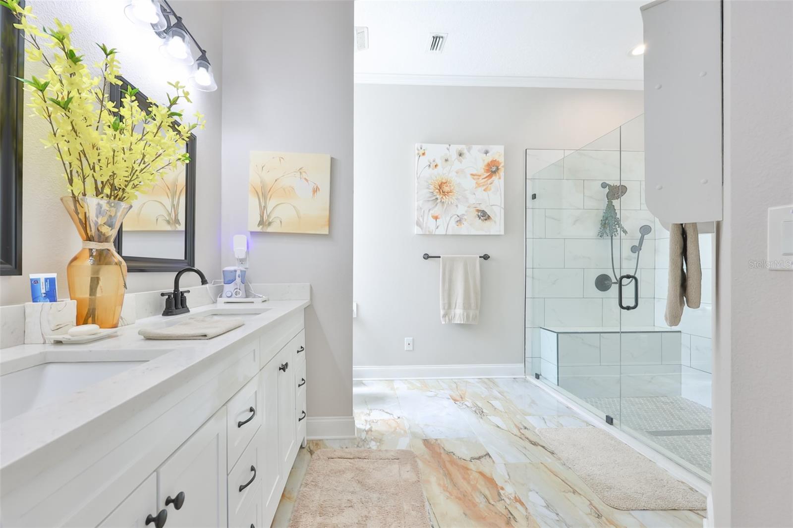 Primary ensuite bathroom is large with the porcelain tile, carried through it, boats of all modern and updated finishes with a large walk in closet to the far right of the picture.