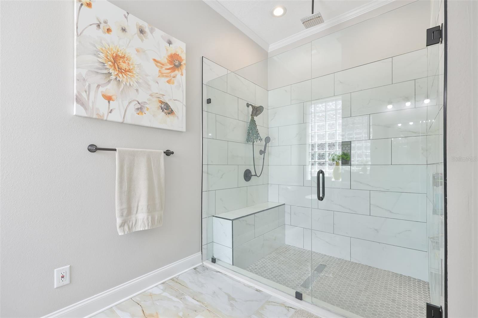 The walk in shower is massive with modern features and a tiled bench