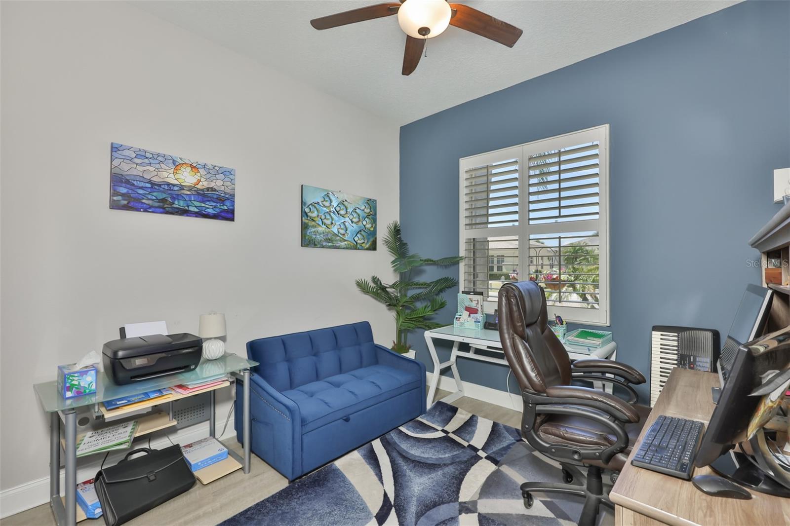 Bedroom #2 is  currently used as an office, but offers a large window with plantation shutters and neutral paint tones.